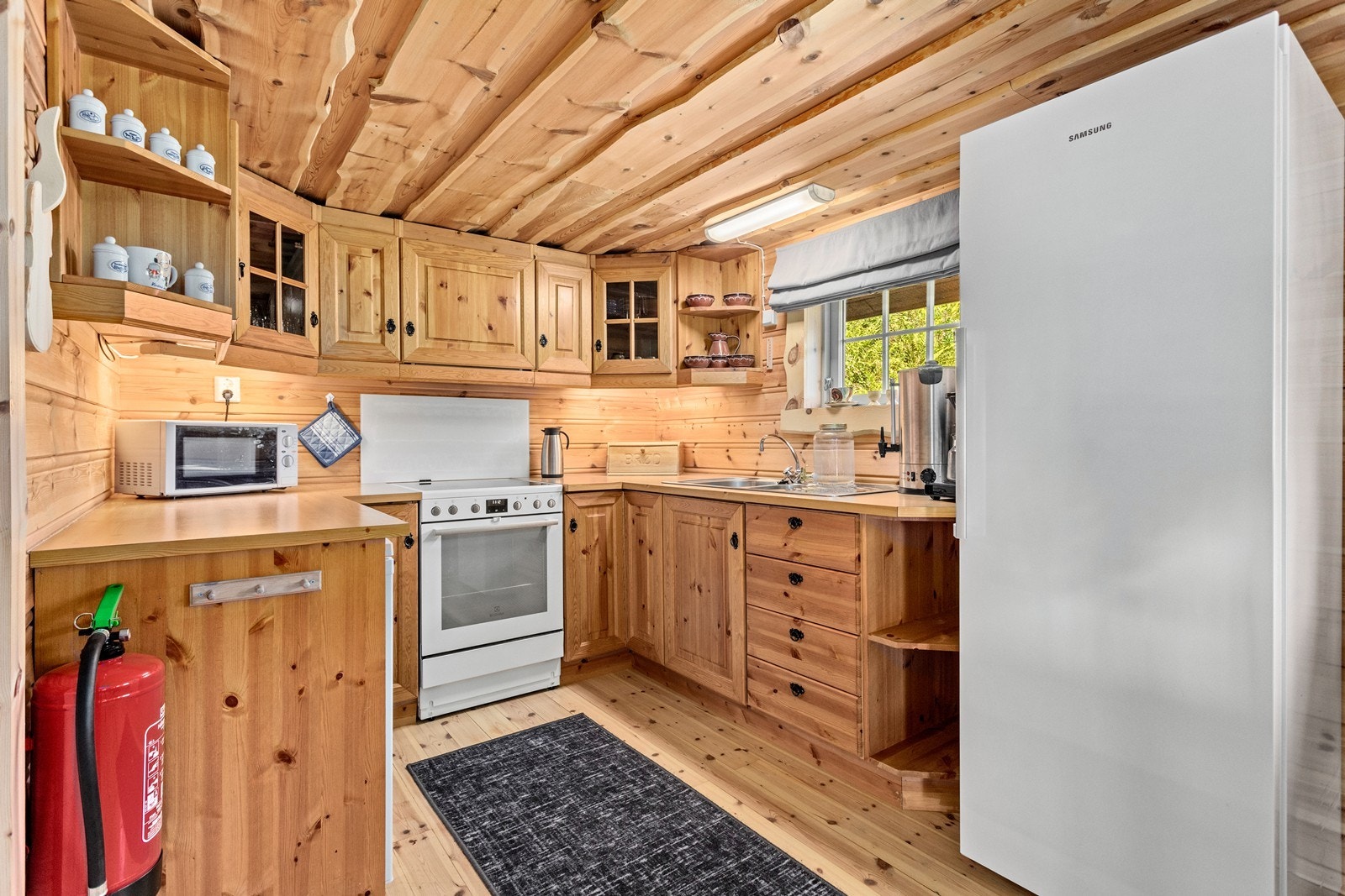 Romsleg kjøkken med mykje skap- og benkeplass. Galleribilde