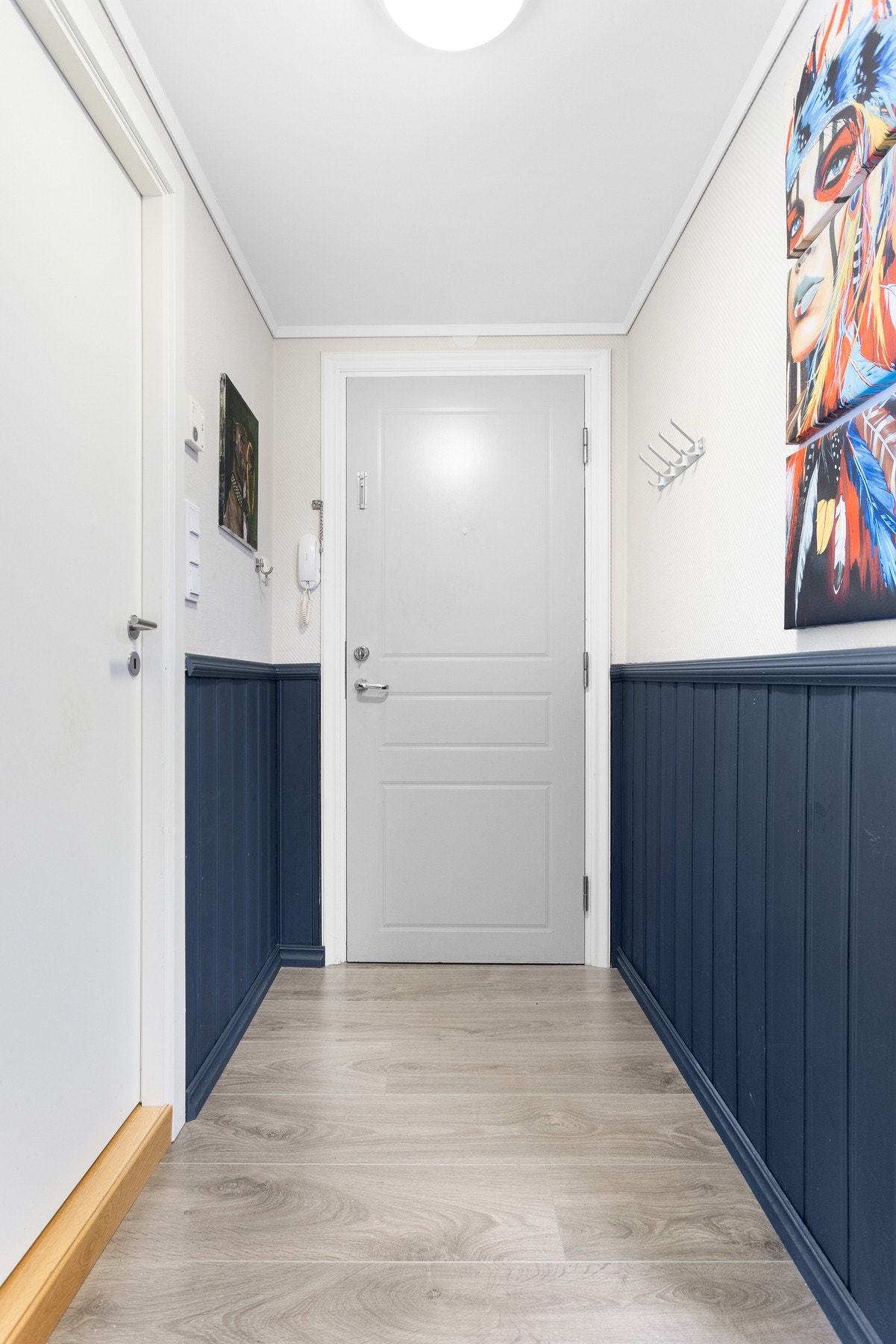 Pent inngangsparti i 4. etg. med montert porttelefon. Her har man god plass til lagring av klær og sko. Galleribilde