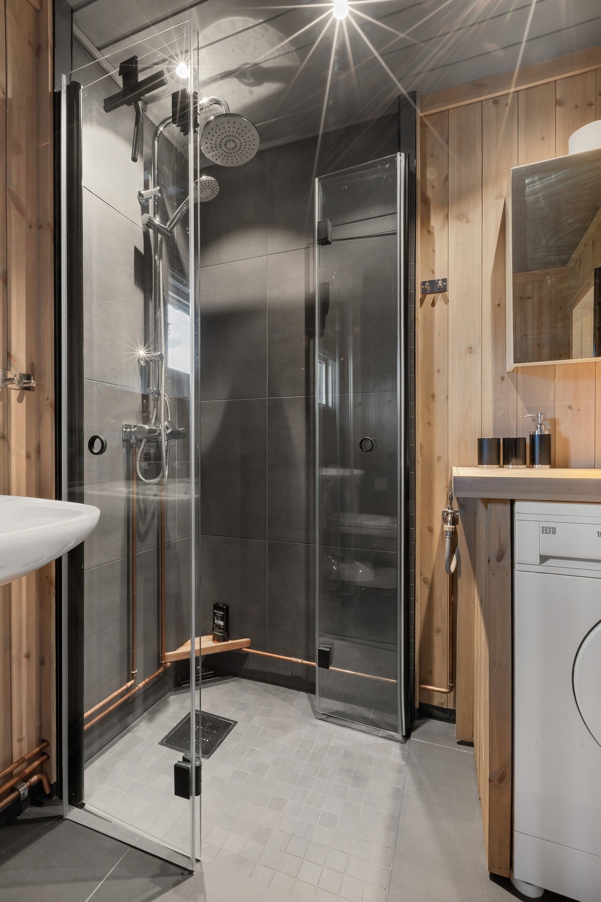 Badet i hytta ble oppgradert i 2020. Rommet har fliser på gulv og deler av vegg - i dusjsona, kombinert med panel. Galleribilde