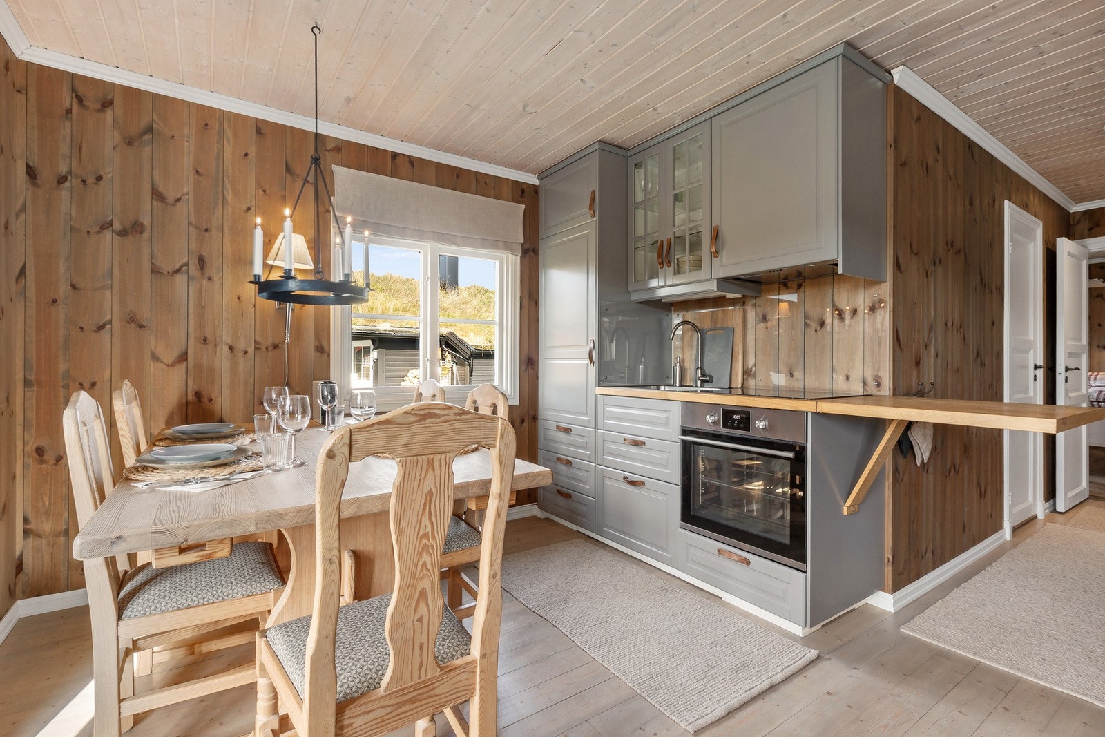 Løsningen er åpen mot stuen, noe som skaper en sosial atmosfære og gjør det enkelt å kombinere matlaging med samvær. Galleribilde