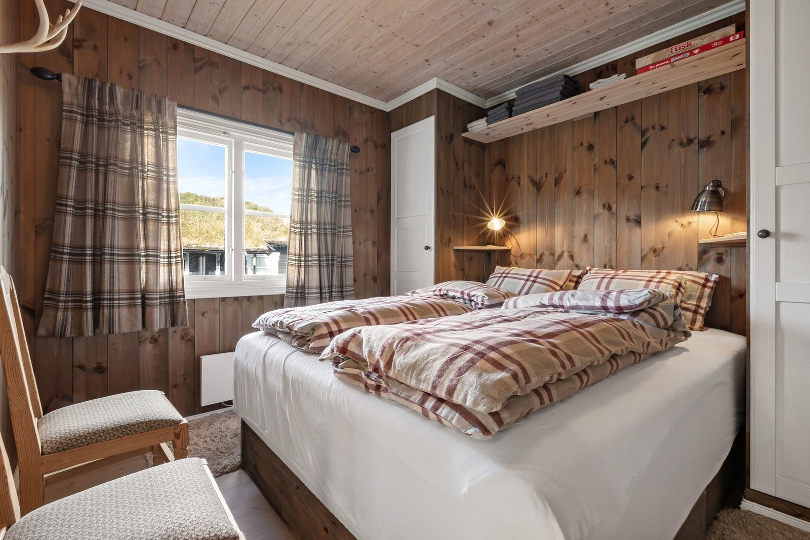 Hytta har to hyggelige soverom med panel på vegger og himling. Galleribilde