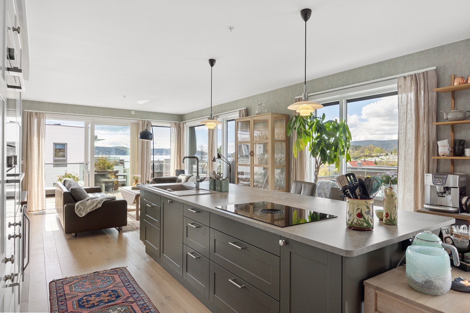 Kjøkkenet ligger sentralt plassert i åpen løsning mot stuen og fungerer som et naturlig bindeledd mellom spiseplassen og loungeområdet Galleribilde