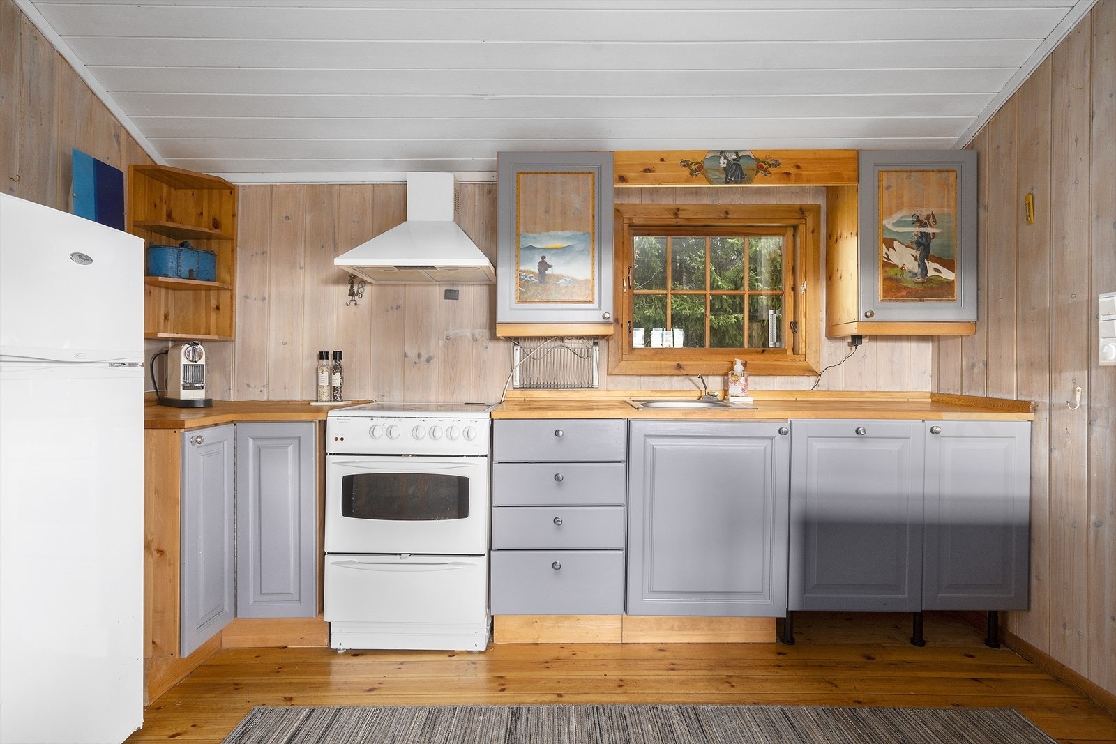 Kjøkkenet har innredning med profilerte fronter i grå/blå utførelse. Galleribilde