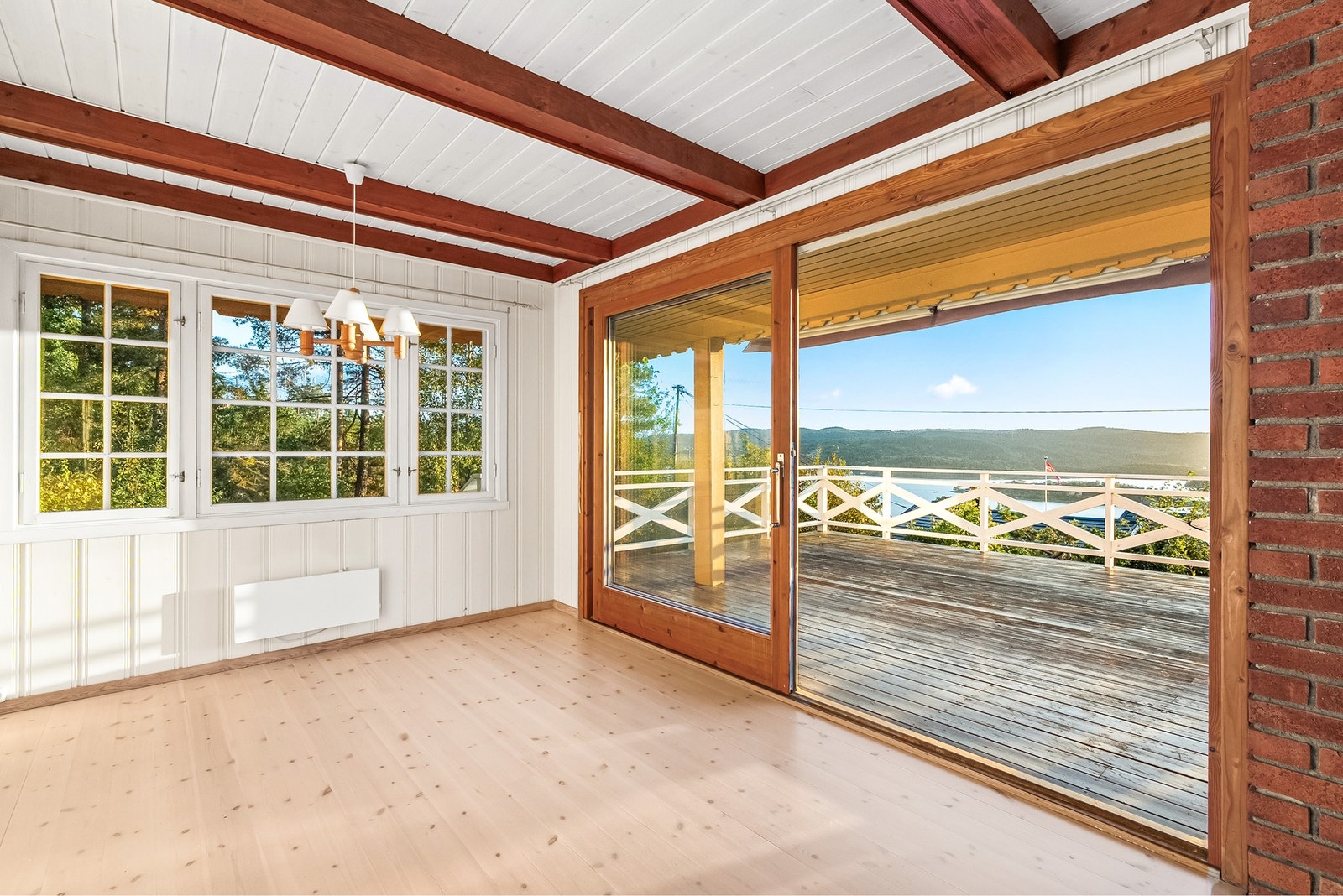 Stuen får godt med naturlig lysinnslipp via skyvedør og store vindusflater. Galleribilde