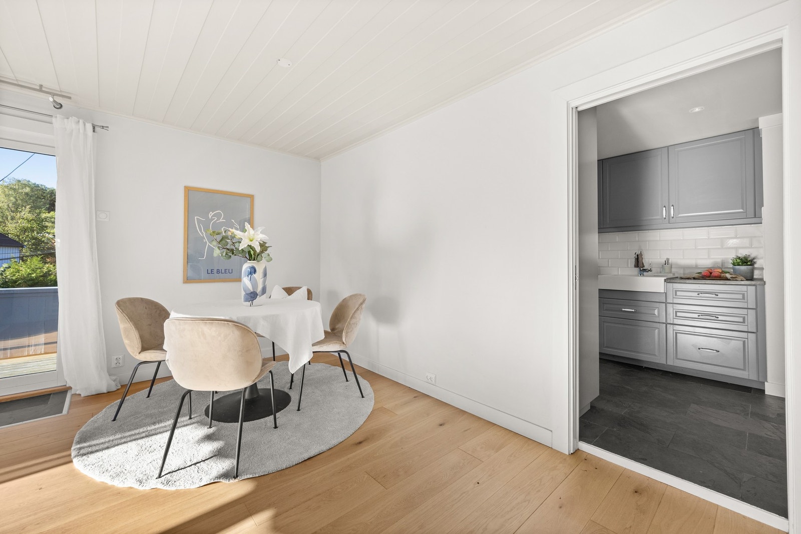 Boligens stue ligger i en delvis åpen løsning med kjøkkenet som bidrar til å skape en større sosial sone Galleribilde