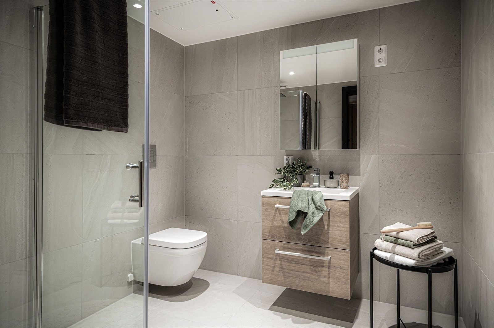 Baderom nr 2 finner man i tilknytning til entréen, innredet med baderomsinnredningen fra Bano Home med hvit servant, speilskap, vegghengt toalett med softclose, dusjvegger, servantarmatur fra Grohe Eurocube og dusjsett fra Grohe Eurocube Galleribilde