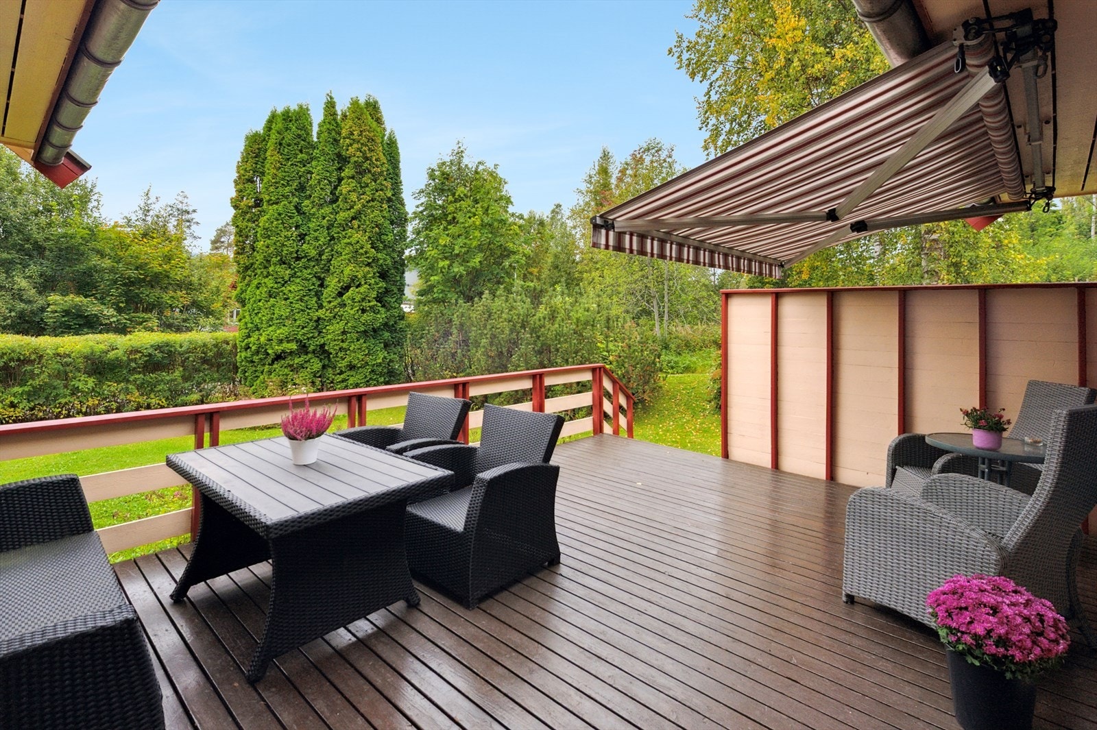 Adkomst til en stor terrasse fra stuen. Her kan man nyte avslappende stunder | Frodig beplanting rammer inn tomten og gir ekstra privatliv. Galleribilde