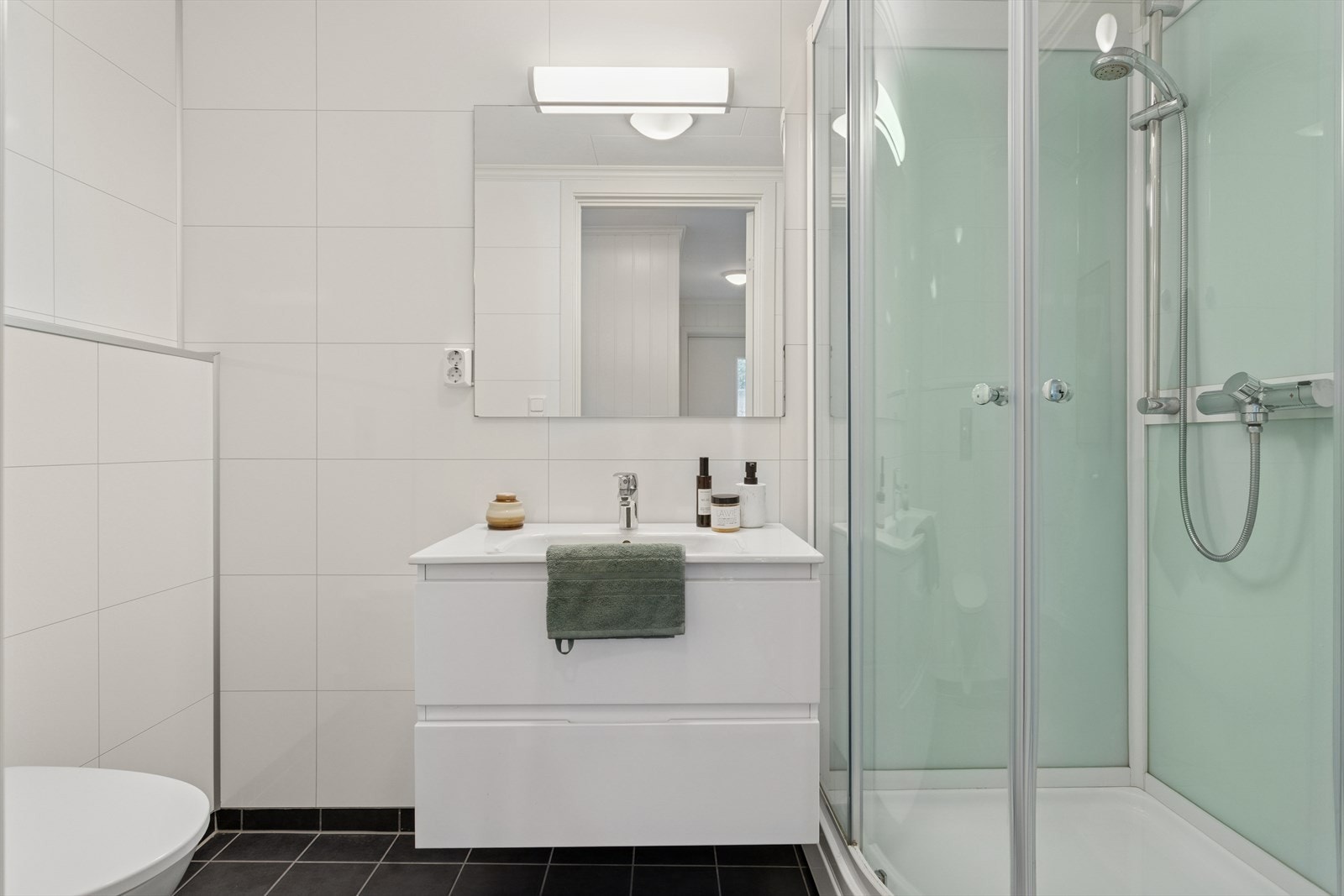 Baderommet i sokkeletasjen er innredet med servantinnredning, vegghengt toalett og dusjkabinett. Galleribilde