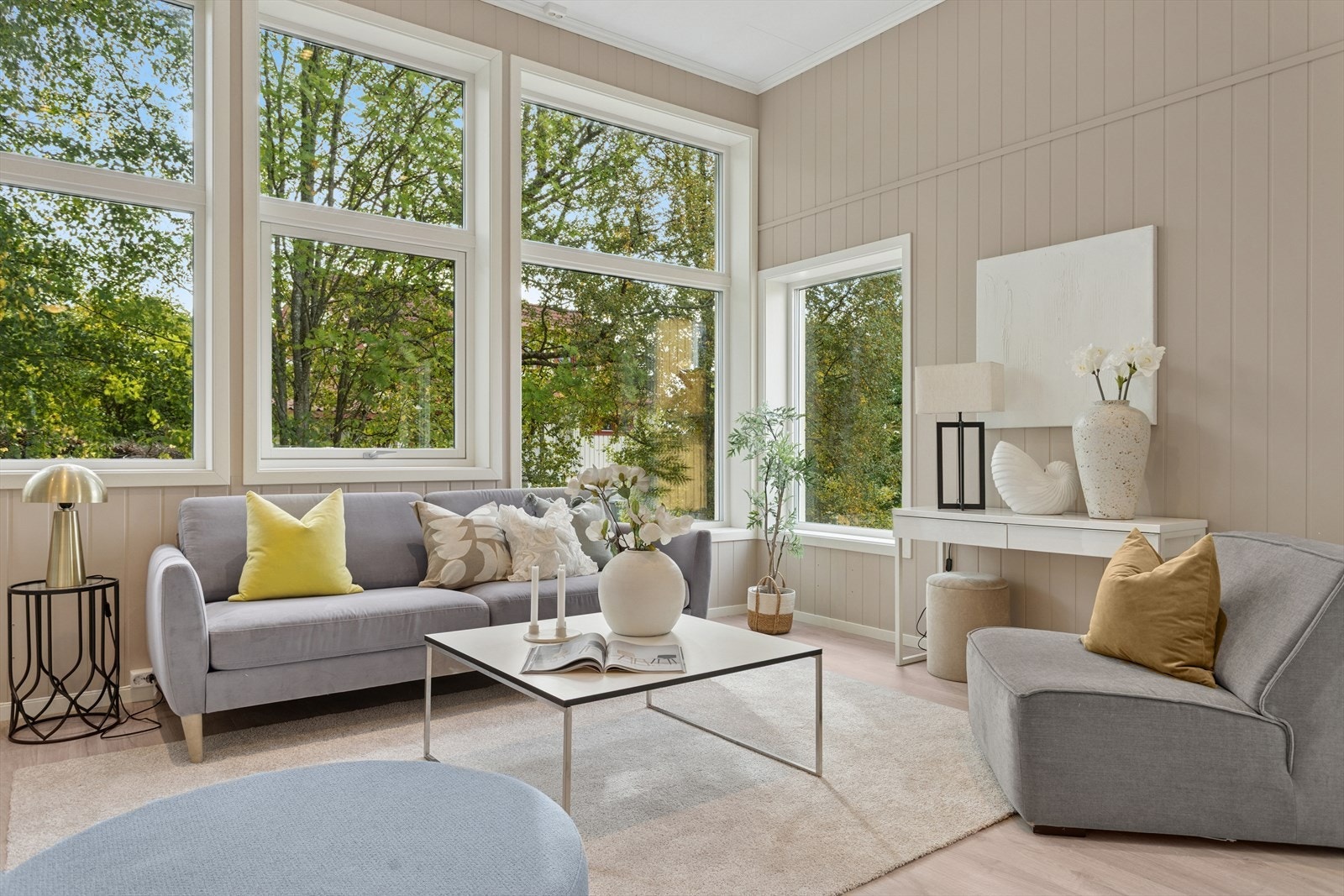 Sofagruppen er plassert ved de store vinduene, noe som gir en lys og innbydende sitteplass. Galleribilde