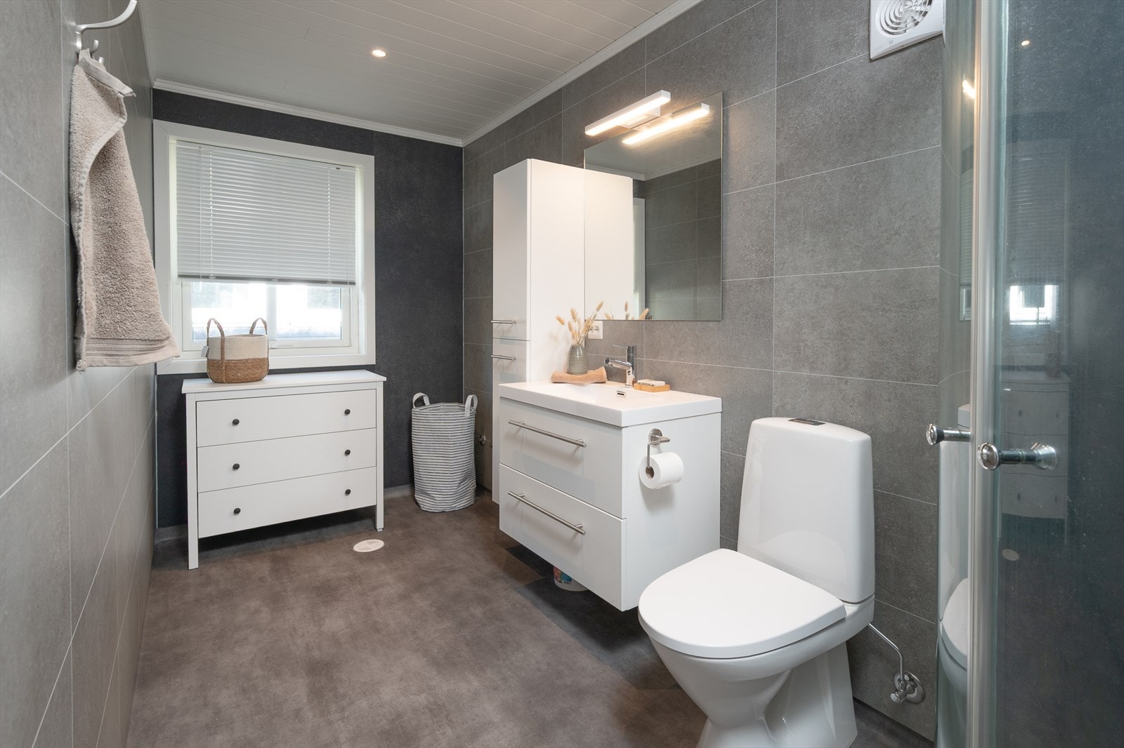 Stort bad med wc, dusj, stilren innredning og opplegg for badekar Galleribilde