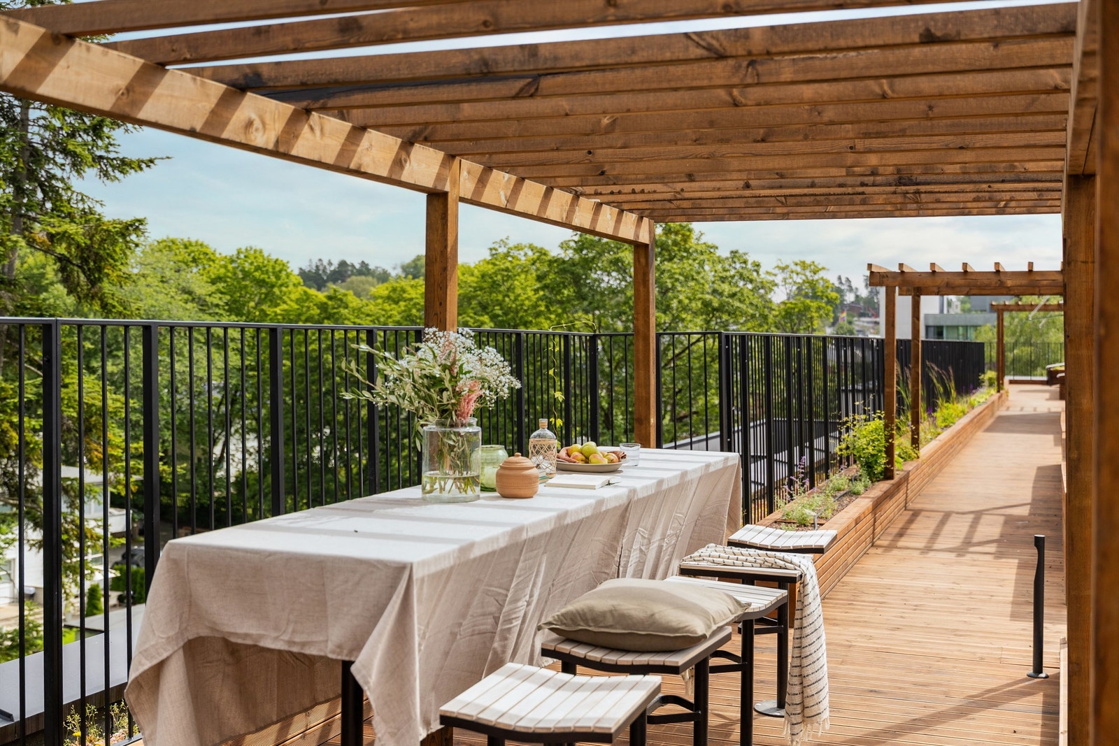 Takterrassen strekker seg over hele bygget og er delt opp i ulike soner med langbord og sittegrupper.jpeg Galleribilde