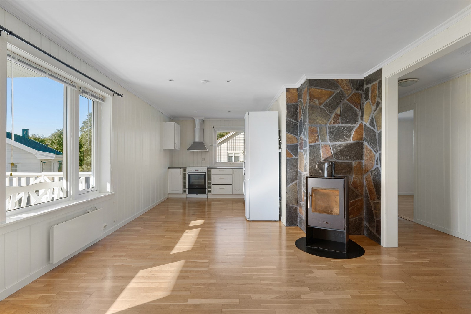 Romløsningen er effektiv med stue og kjøkken i åpen løsning. Vedovnen er stemningsfremmende og en alternativ kilde til oppvarming av leiligheten. Galleribilde