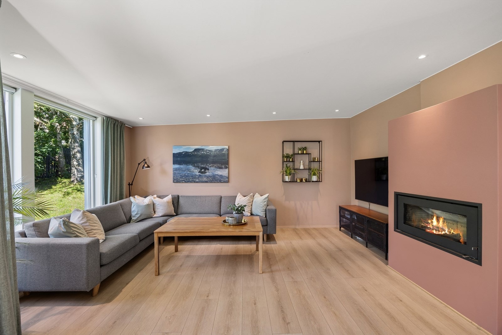 Stuen er av god størrelse med plass til stor sofagruppe og TV. Det er montert en moderne peisinnsats som både varmer godt og skaper hygge Galleribilde