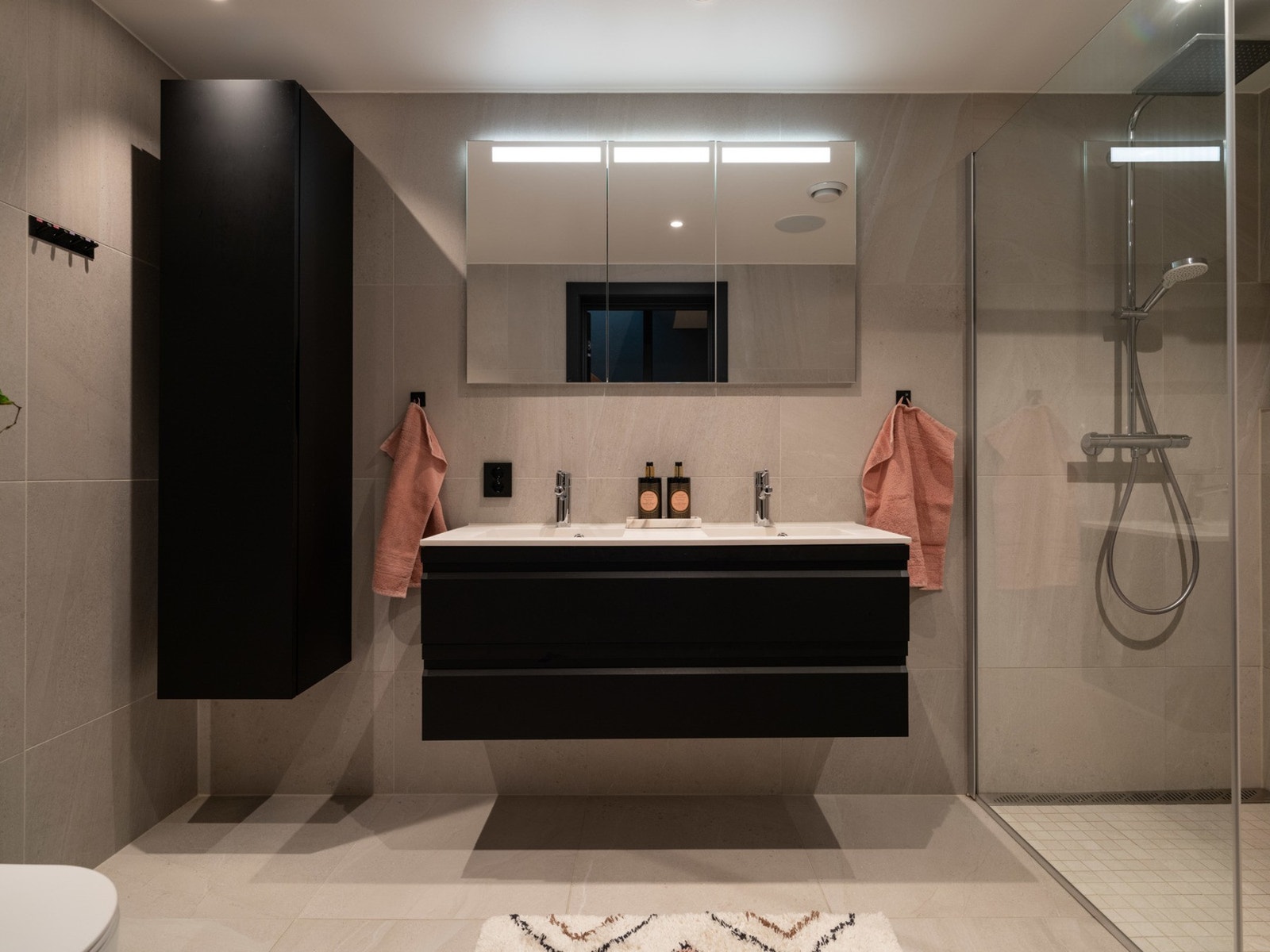 Utstyrt med et stort dusjhjørne med regndusjhode, nisje i veggen, servant og servantskap, vegghengt toalett og speilflater med oppbevaring bak. Galleribilde