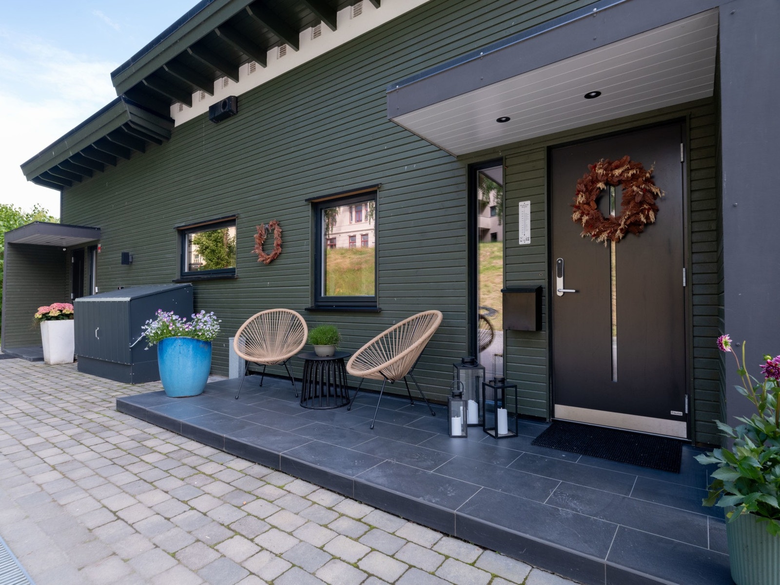 Begge inngangsdørene sett utenfra. Elbil-lader er installert rett ved inngangsdøren. Galleribilde