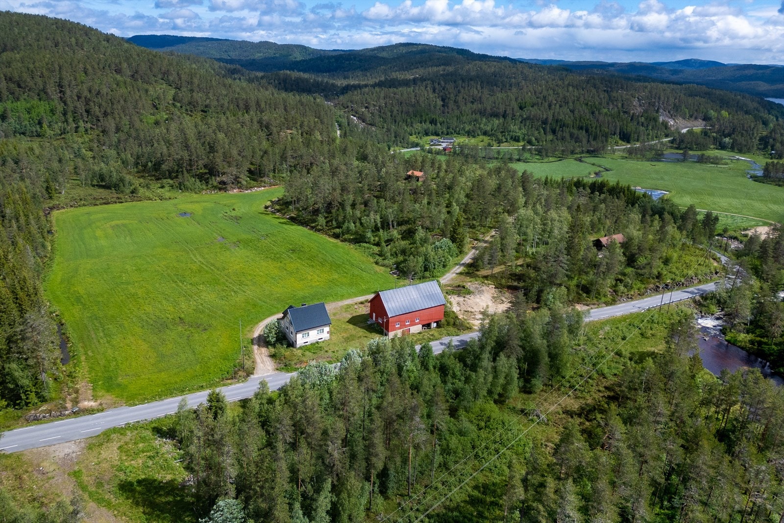 Eiendommen er omkranset av jorder og skog Galleribilde