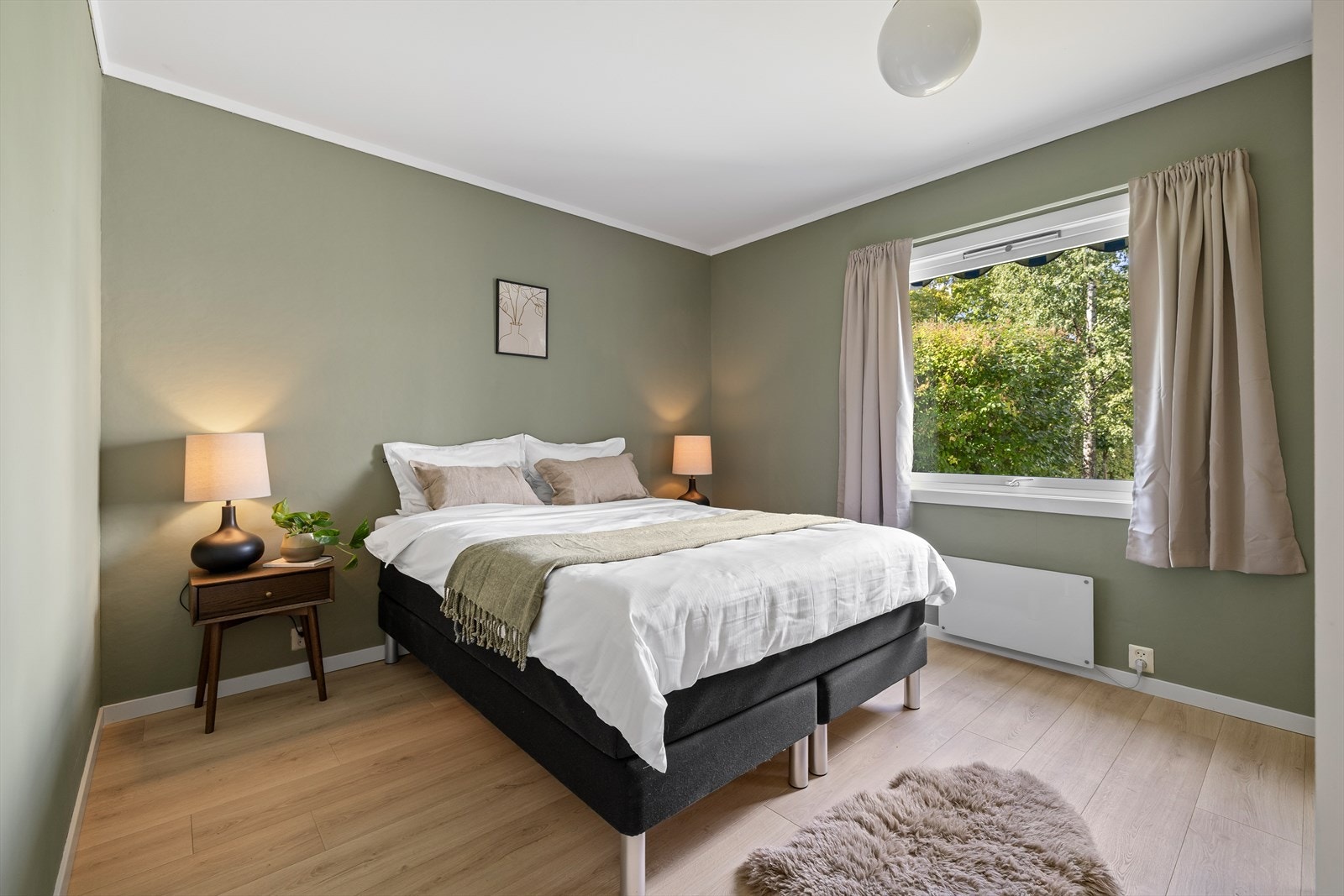 Lunt soverom med god plass til dobbeltseng og tilhørende nattbord Galleribilde