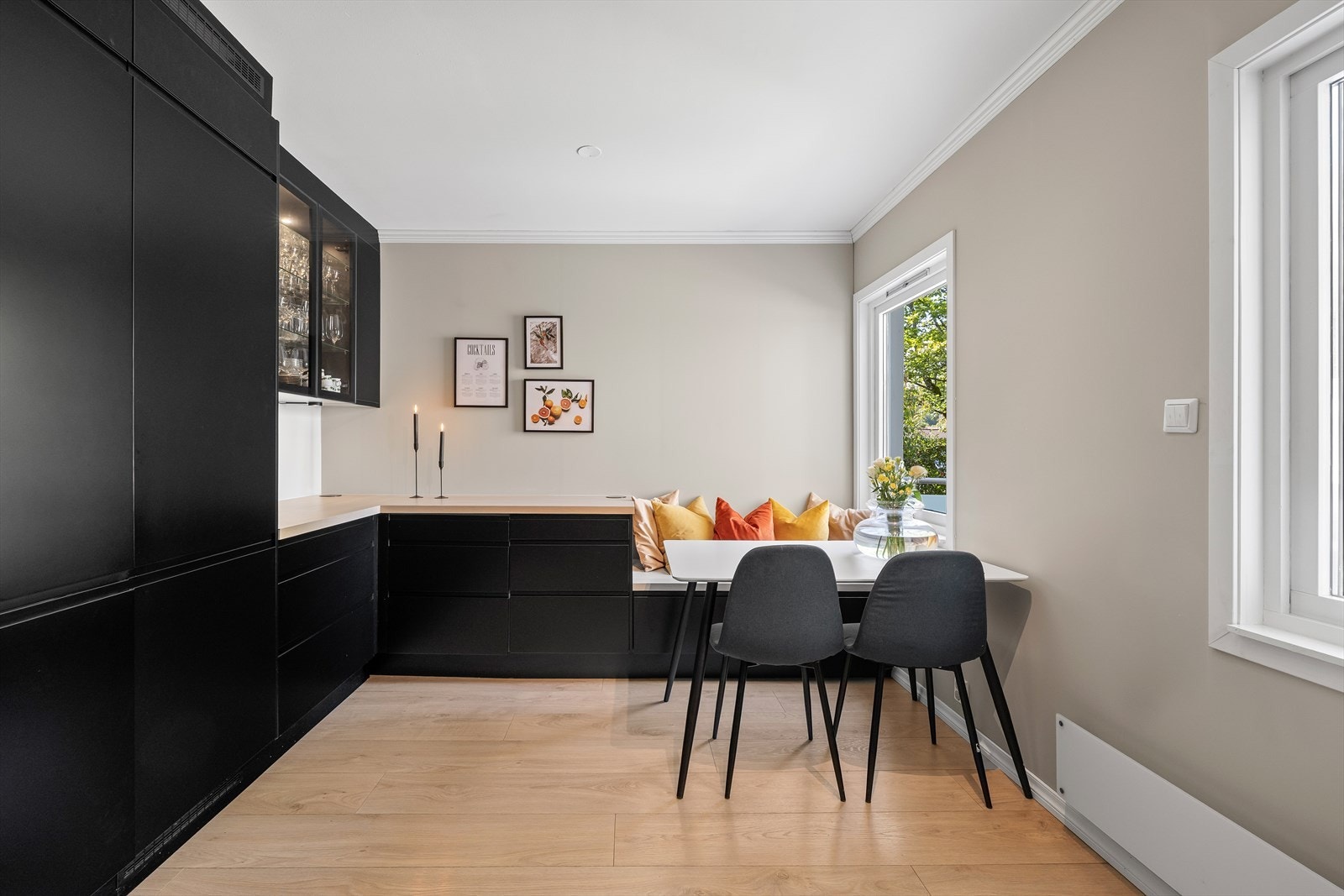 Lekkert kjøkken fra 2022 med sorte slette fronter og laminat. Det er bygget sitteplass på kjøkkenet, perfekt for hektiske hverdager Galleribilde