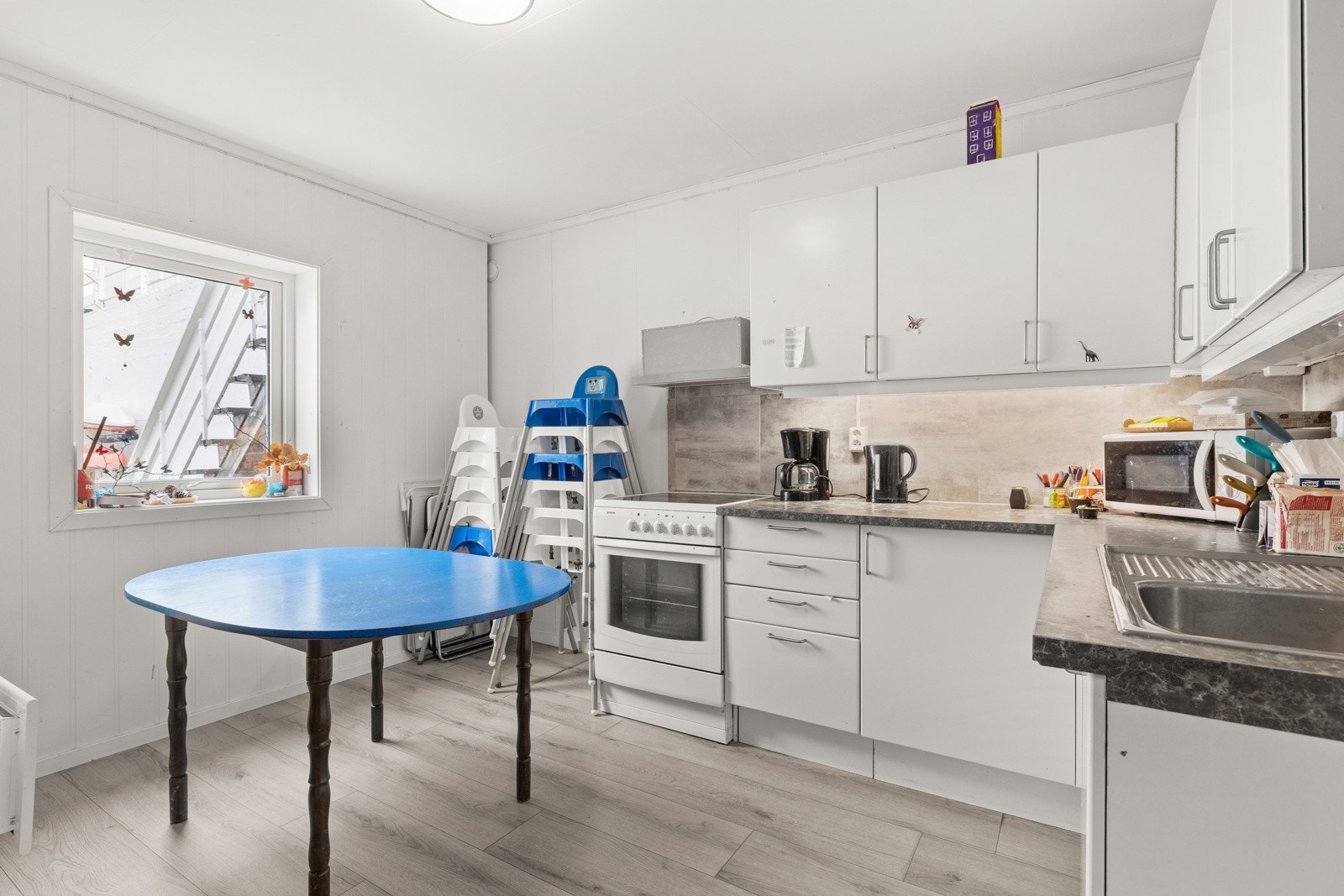 Innredningen består av glatte, hvite fronter kombinert med laminat benkeplate med nedfelt stålkum, rillebrett og ettgreps kjøkkenkran. Galleribilde