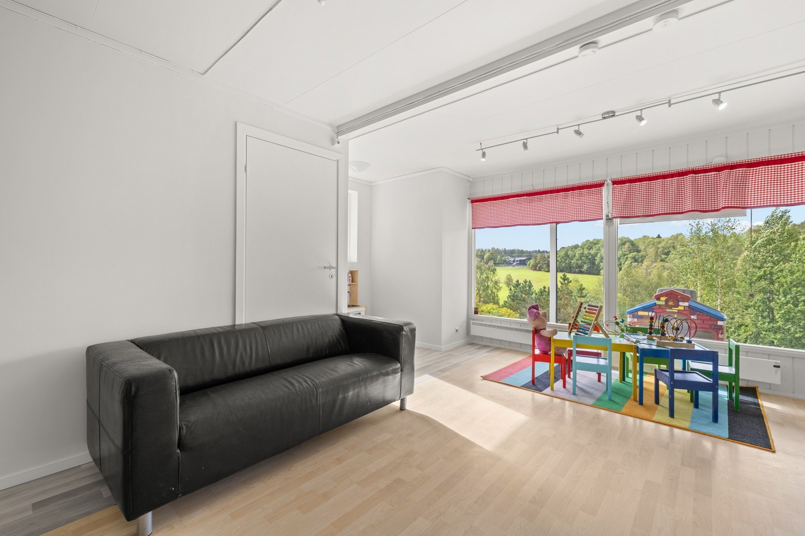 Store vindusflater vender mot hagen og slipper inn rikelig med naturlig lys, samtidig som de gir en flott utsikt over grønne omgivelser. Galleribilde