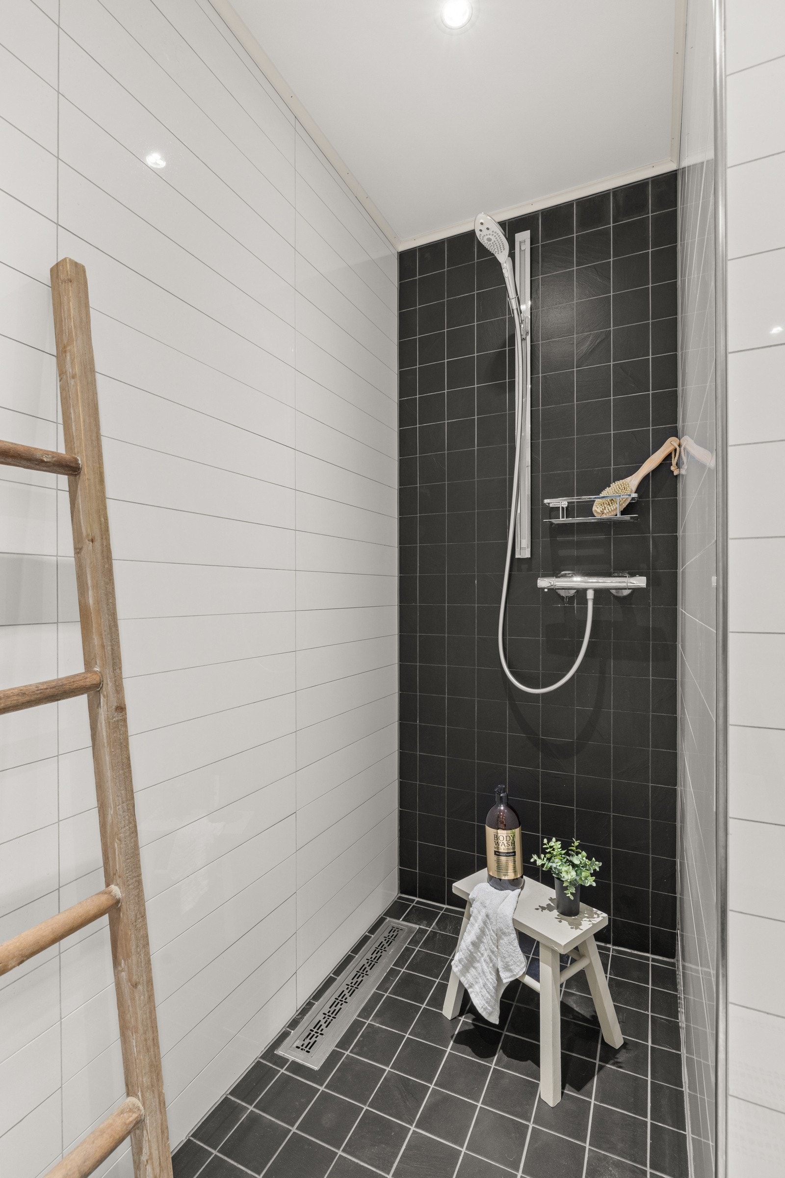 Gulvet er støpt med varmekabler og belagt med 30x30 fliser, mens dusjsonen har mindre 10x10 fliser og slukrenne langs vegg. Galleribilde