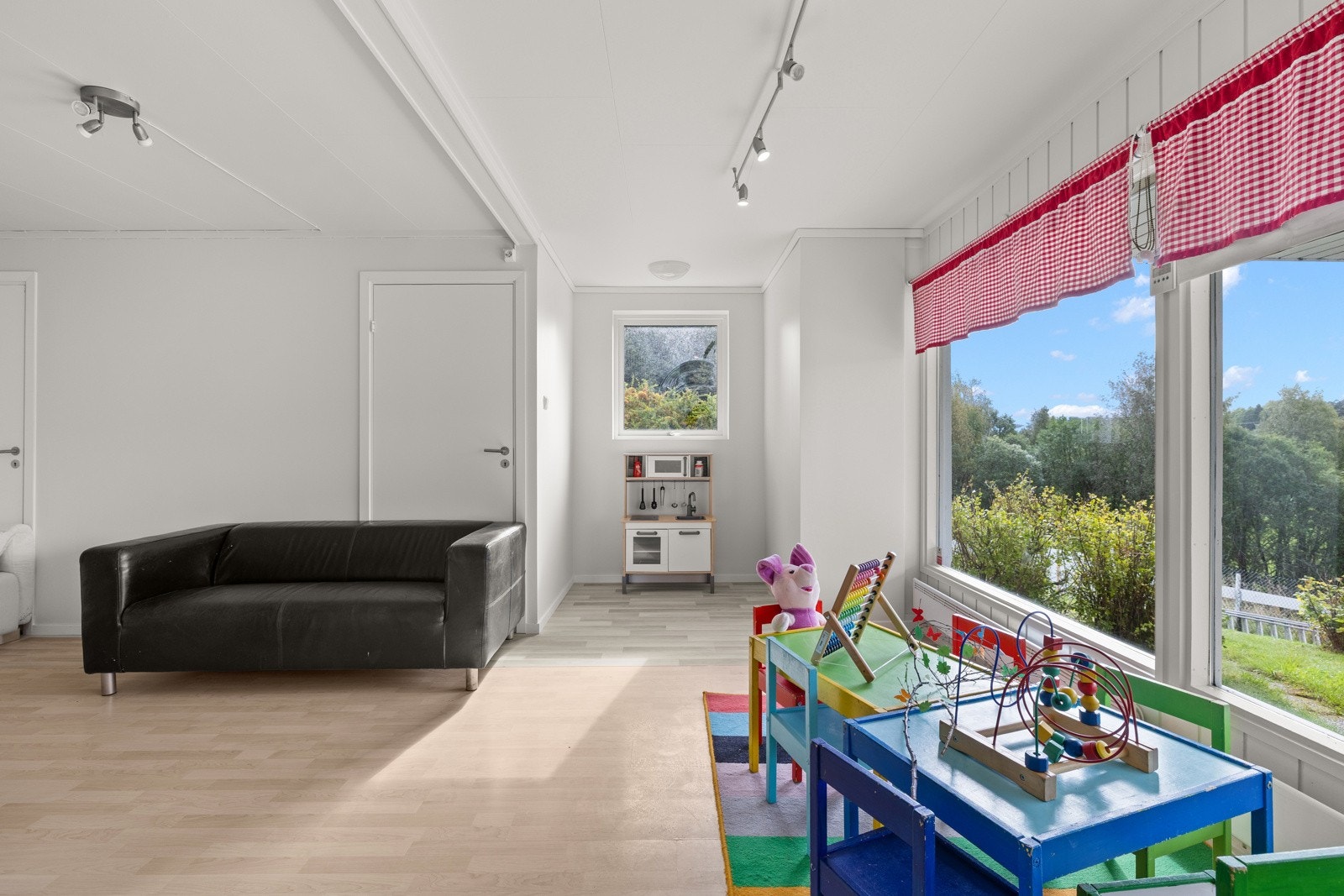 Underetasjen har en romslig stue som i dag benyttes som oppholdsrom for barnehagedriften. Galleribilde