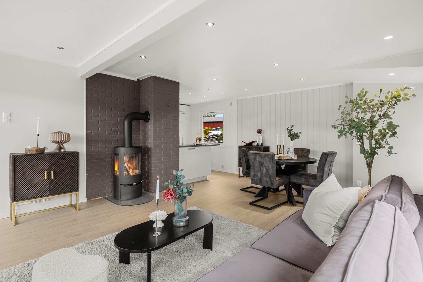 En stilren vedovn gir både varme og hygge på kjølige kvelder, mens varmepumpe bidrar til ekstra komfort. Galleribilde