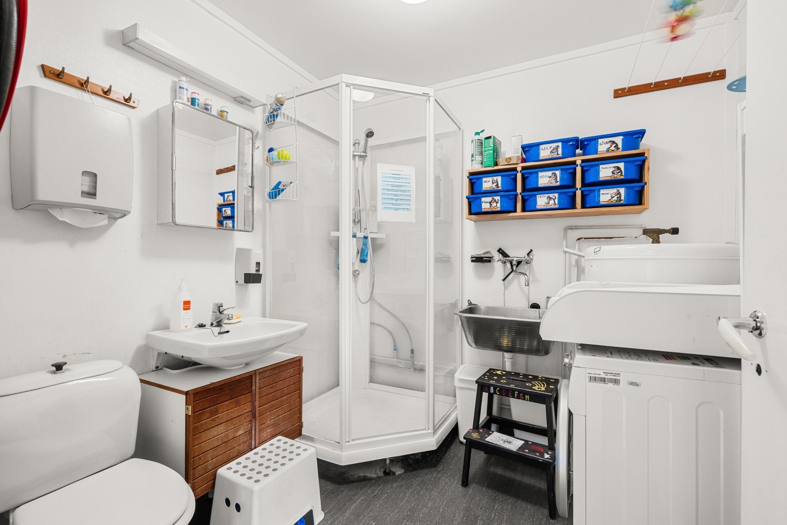 Bad fra byggeåret med vinylbelegg på gulvet med oppkant til vegger, malt våtromstapet på vegger og malt himling. Galleribilde