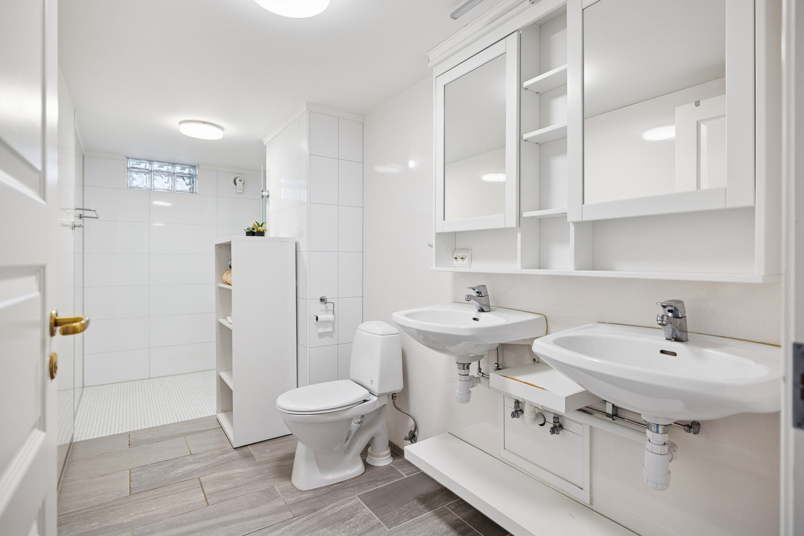 Innredningen inkluderer to servanter, toalett og et romslig dusjhjørne. Galleribilde