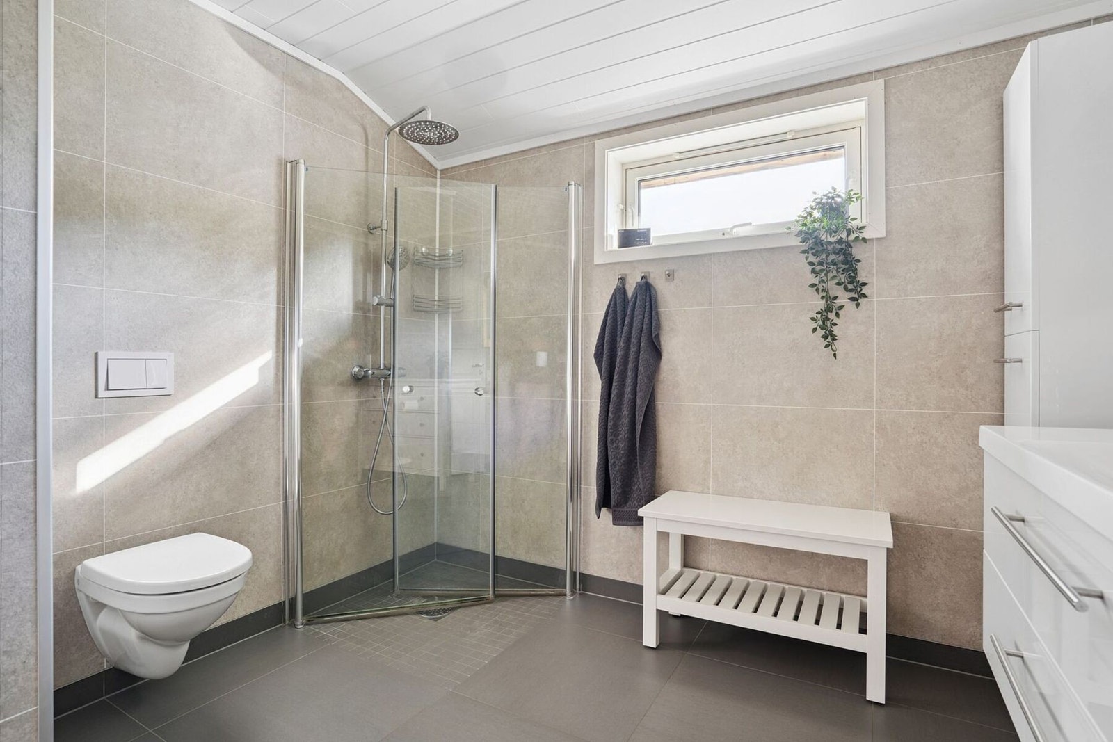 Badet inneholder også vegghengt toalett og dusj med innfellbare glassvegger. Galleribilde