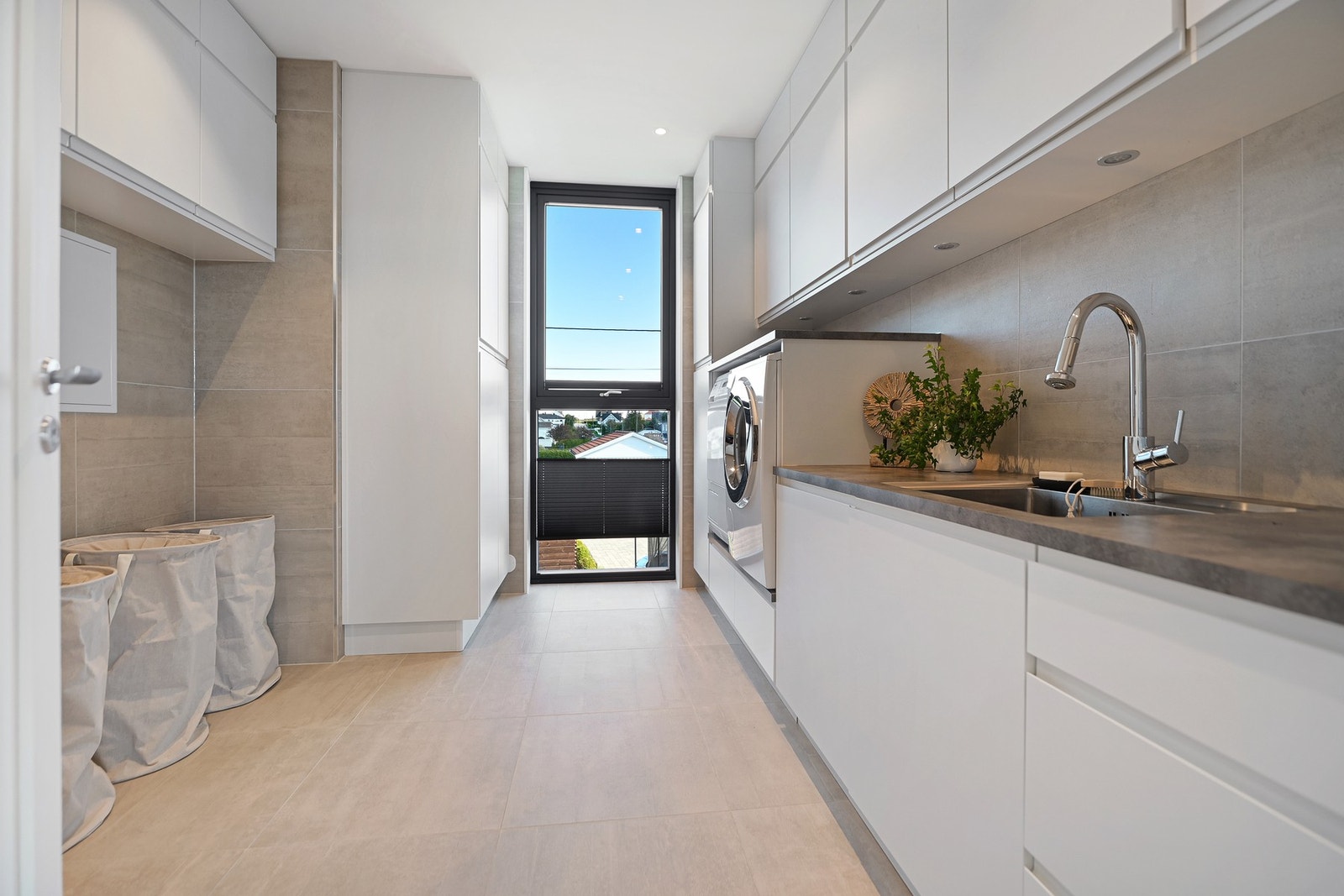 Romslig vaskerom med praktisk innredning og plass for tørkestativ. Galleribilde