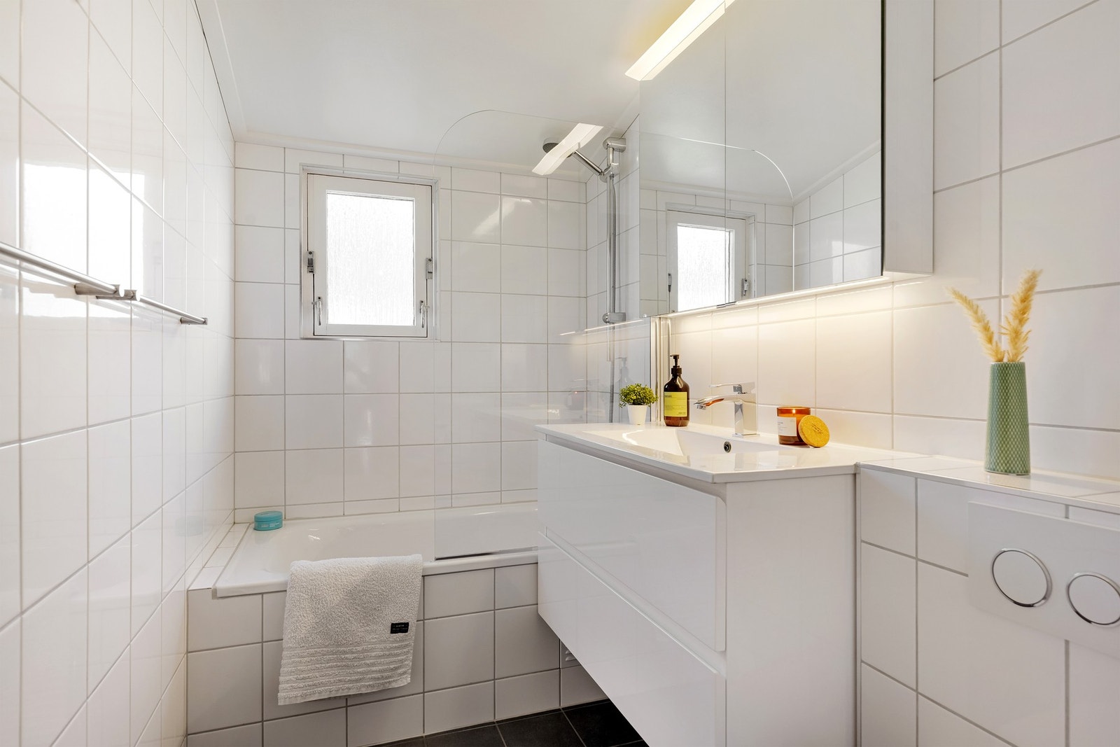 Badet i 2. etasje er innredet med vegghengt toalett, badekar og baderomsinnredning med helstøpt servant med skuffer under og speilskap over. Galleribilde