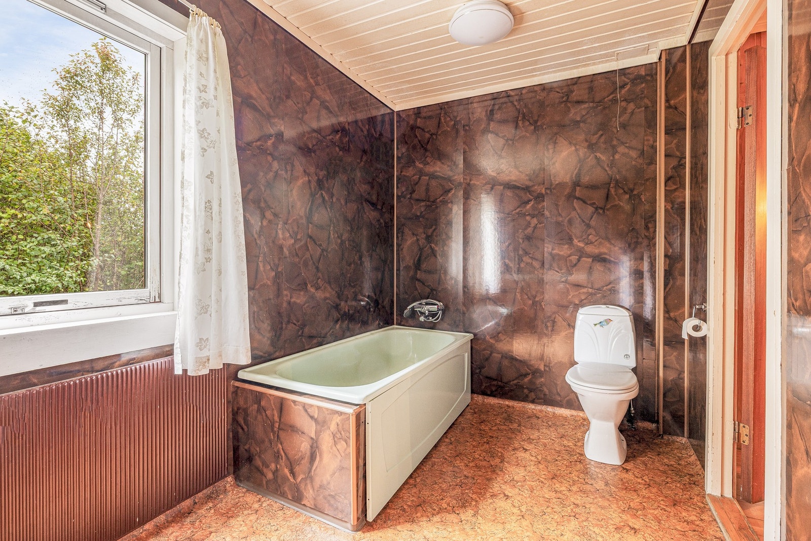 Badet måler 7,3 kvadratmeter og er innredet med badekar, servant og toalett Galleribilde