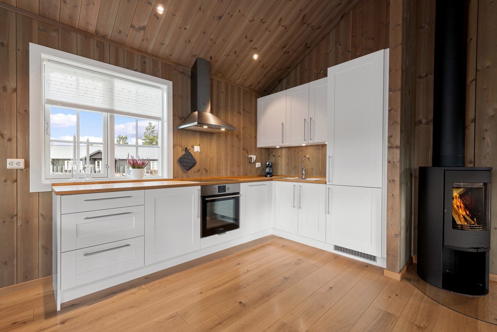 Stilrent kjøkken med lyse fronter og integrerte hvitevarer. Galleribilde