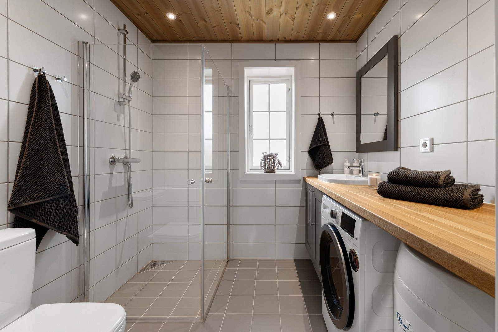 Badet er innredet med toalett, dusj servant med innredning og opplegg for vaskemaskin. Galleribilde