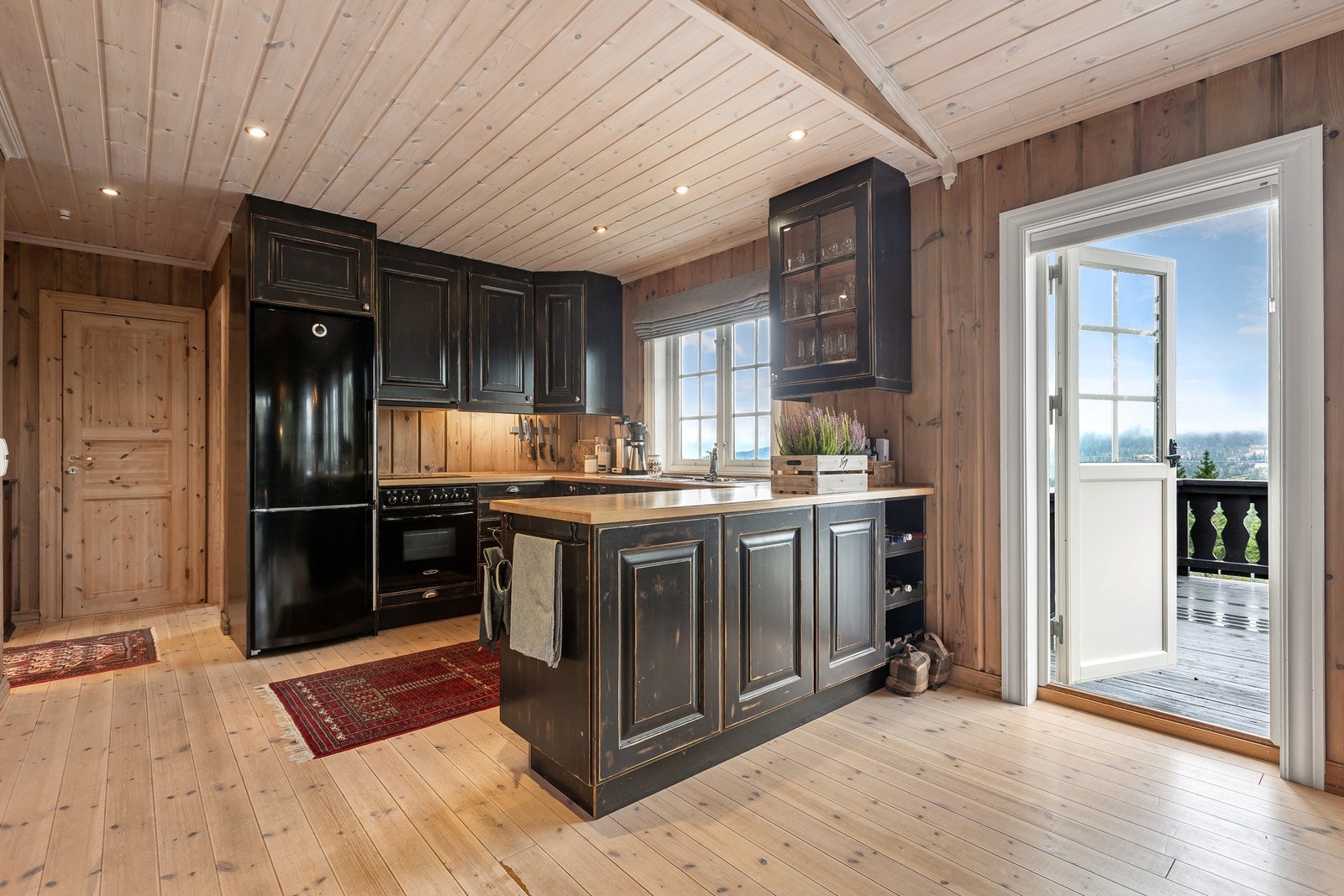 Smakfullt innredet kjøkken med profilerte fronter og benkeplate i heltre i åpen løsning med stuen. Galleribilde