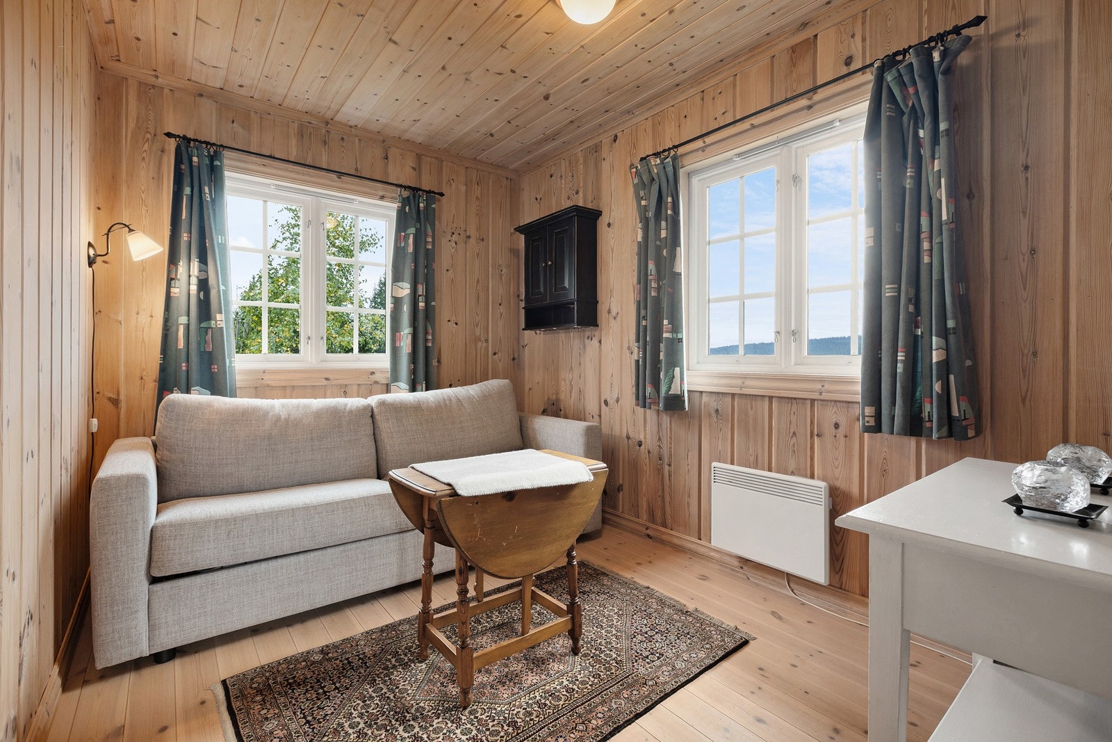 Lunt og koselig oppholdsrom med åpen løsning, panel på vegger og tak samt furugulv. Galleribilde