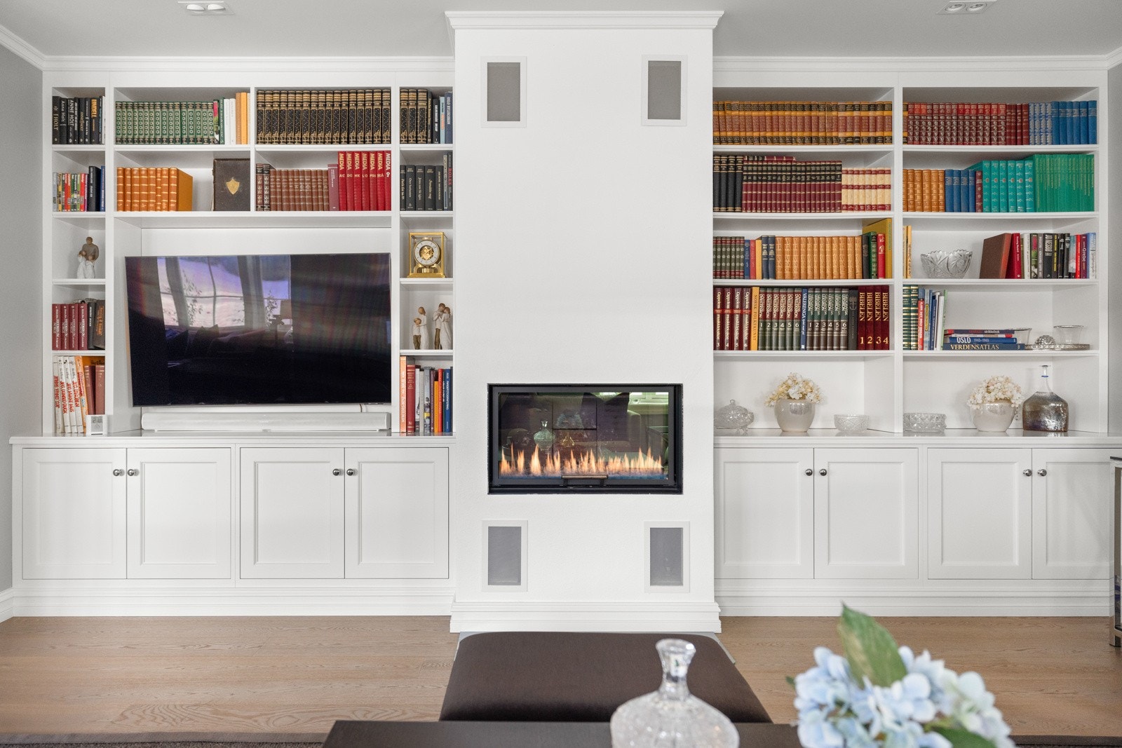 Spesialprodusert innredning fra Gjeving trevare og designpeis med glassdør fra Rais med egen vedskuff. Galleribilde