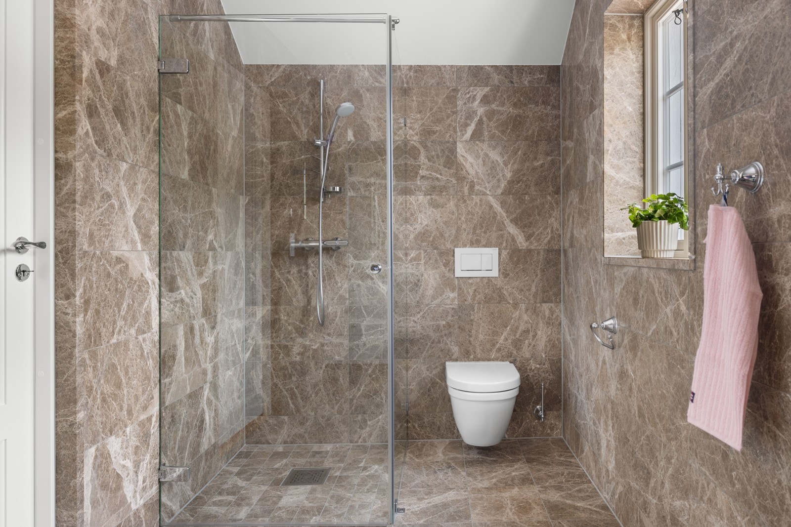 Det er innredet med dusjhjørne med glassvegg/glassdør, skapinnredning med underlimt vask og vegghengt toalett, samt håndklevarmer. Galleribilde