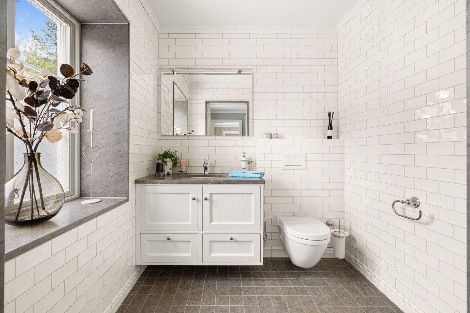 Toalettrommet er innredet med servant på skapseksjon (stenplate med underlimt servant) og vegghengt toalett. Galleribilde