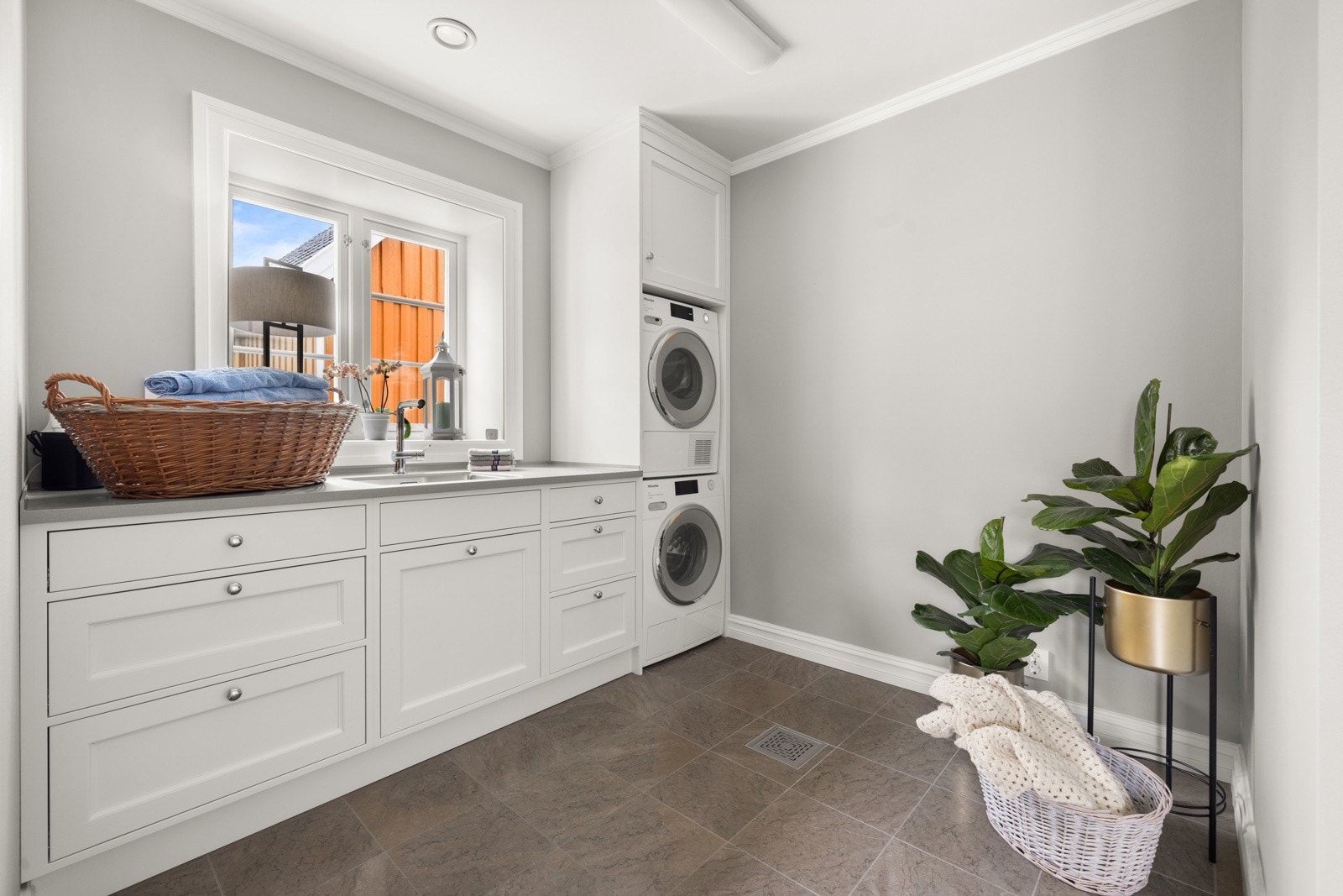 Vaskerommet har mye skapinnredning, kompositt benkeplate med underlimt kum og nisje for vaskesøyle. Galleribilde