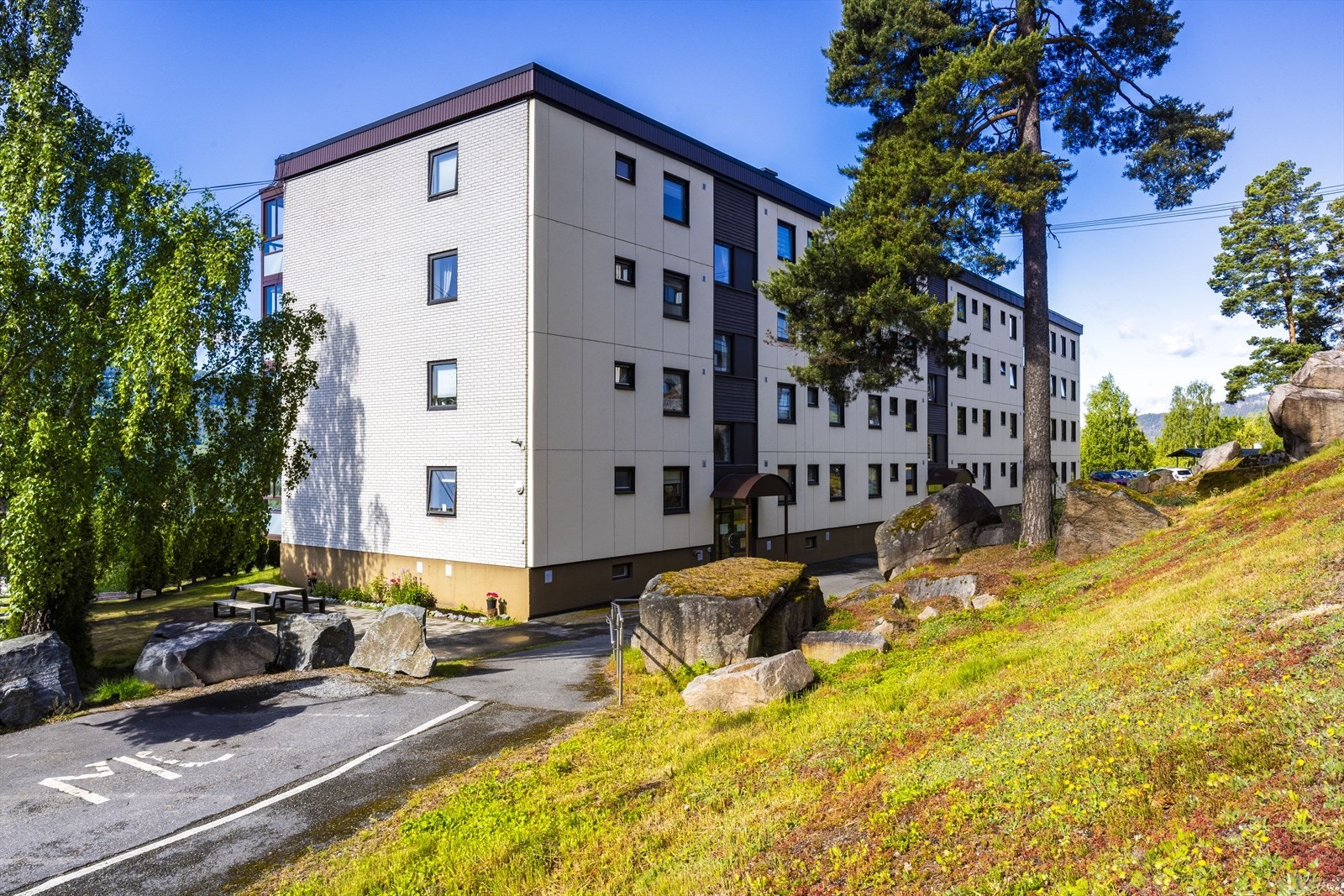 Pen opparbeidet felles tomt for borettslaget. Asfaltert innkjørsel og gårdsplass. Parkering på felles parkeringsplass. Galleribilde