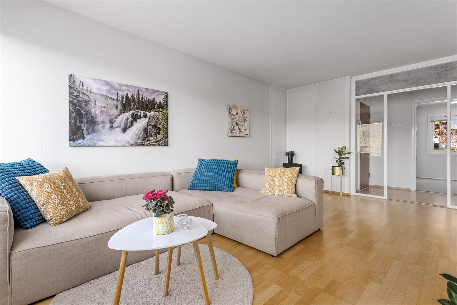 En dekorativ og gjennomtenkt detalj med glassfelt rundt åpningen mot gang og kjøkken tilfører boligen et moderne og luftig preg, samtidig som det skaper en elegant romfølelse og naturlig lysflyt. Galleribilde