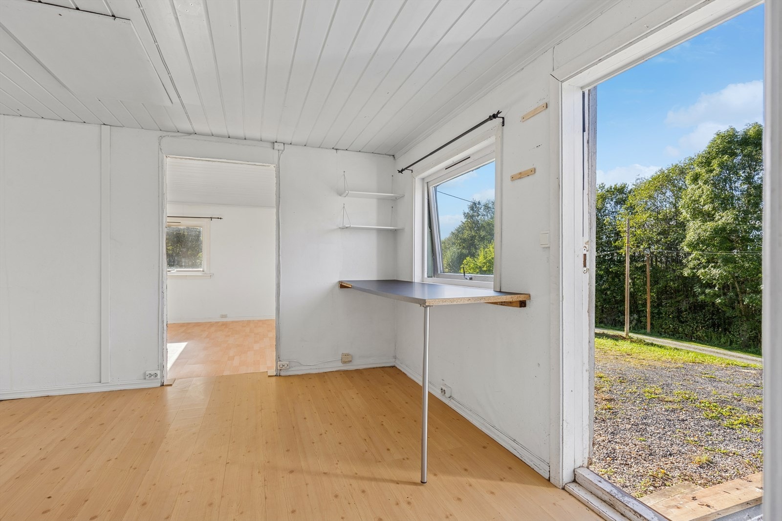 Boligen har adkomst direkte inn på kjøkkenet. Enkel, hvit kjøkkeninnredning med benkeplate og vask. Galleribilde