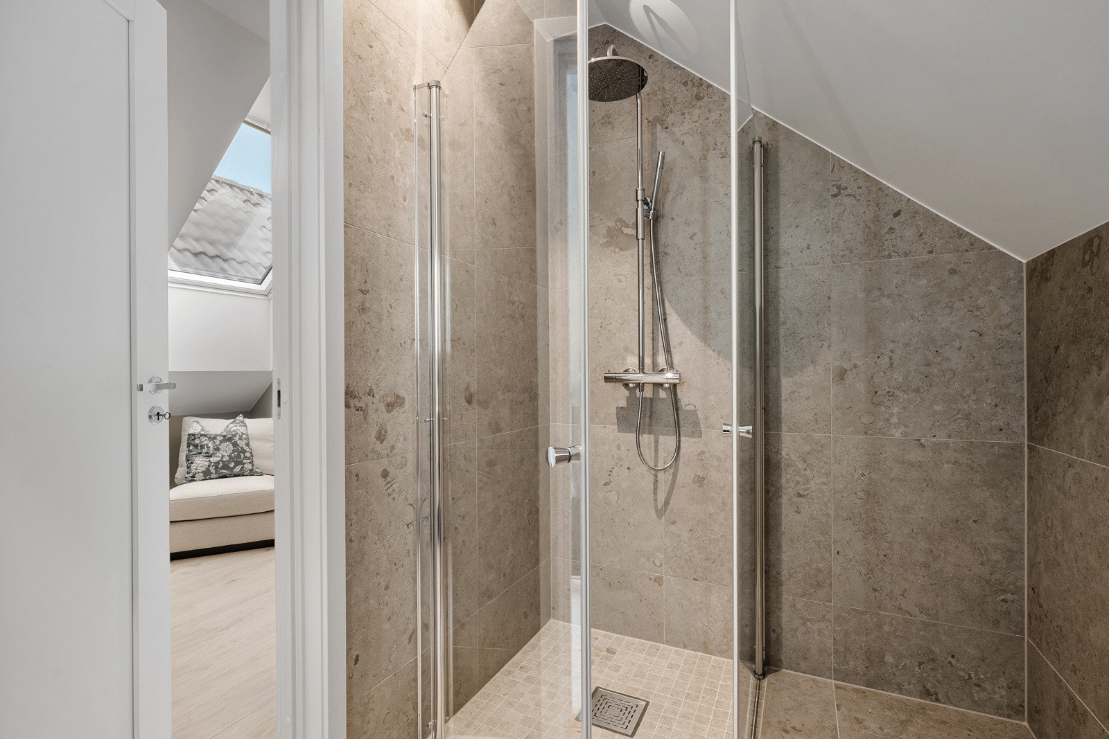 Tidløse armaturer i krom fra VikingBad, komplettert med en stilren regnfallsdusj. Galleribilde