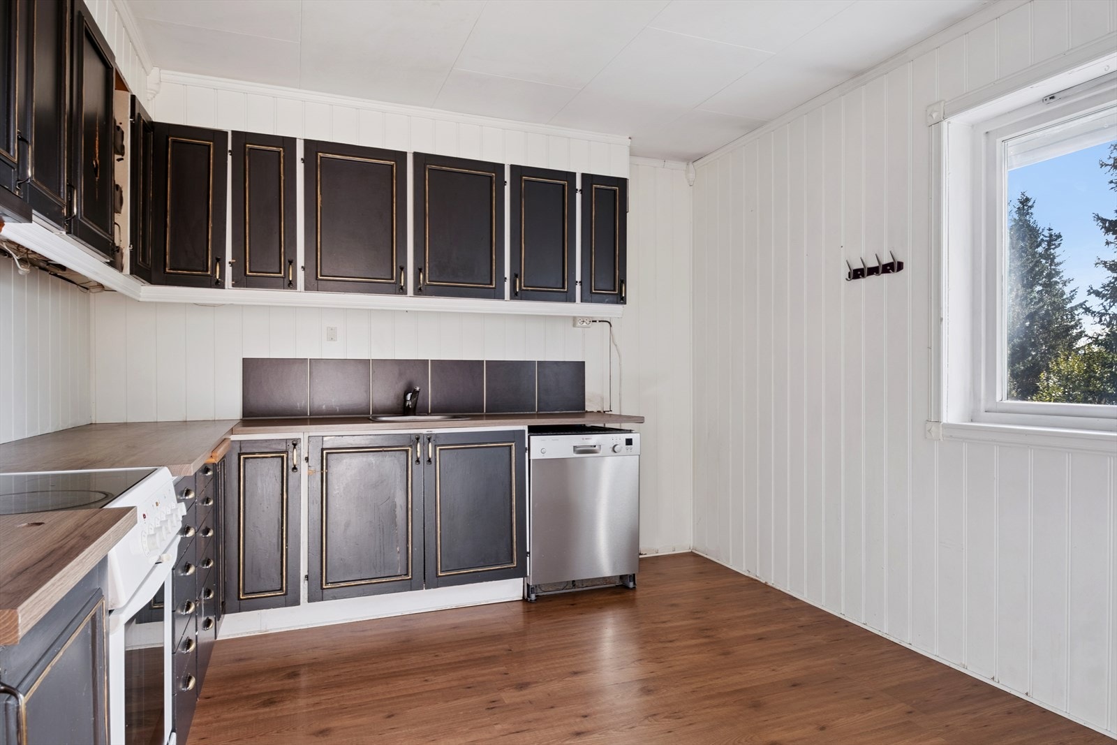 Hjørnekjøkken med profilerte, svarte fronter. Galleribilde