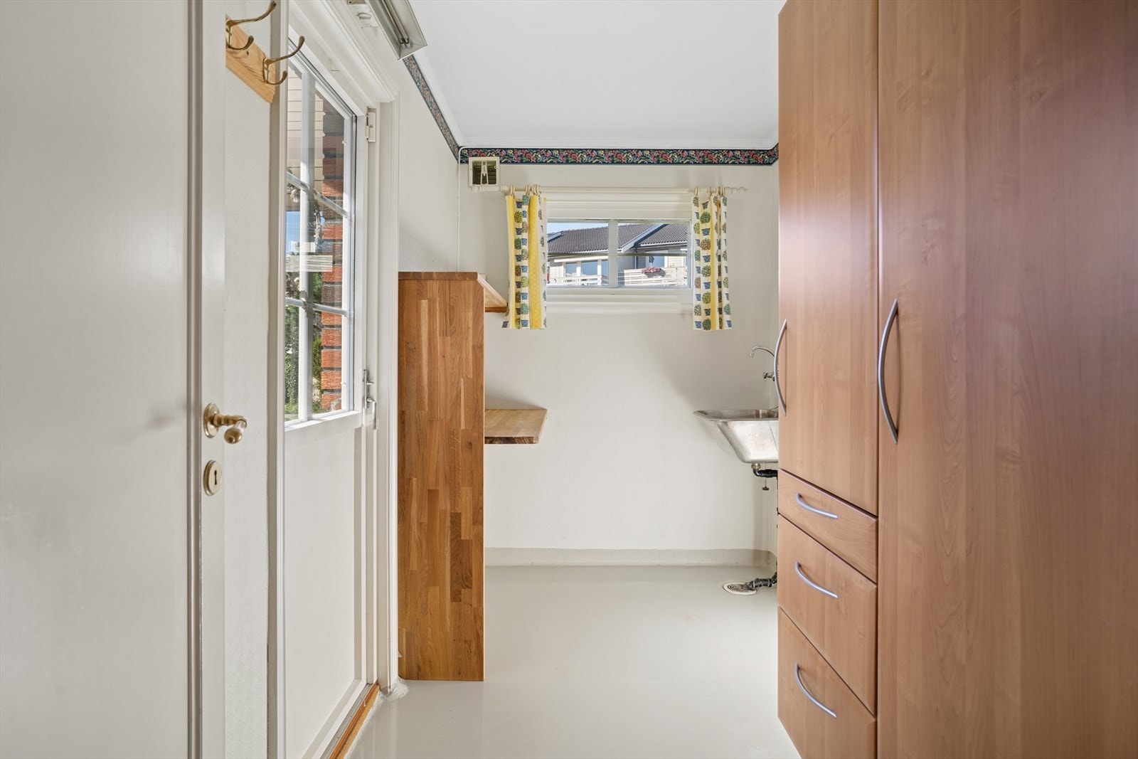 Vaskerom med standard fra byggeår og består av skyllekum i rustfritt stål, opplegg for vaskemaskin og en ståleovn på vegg som varmekilde. Galleribilde