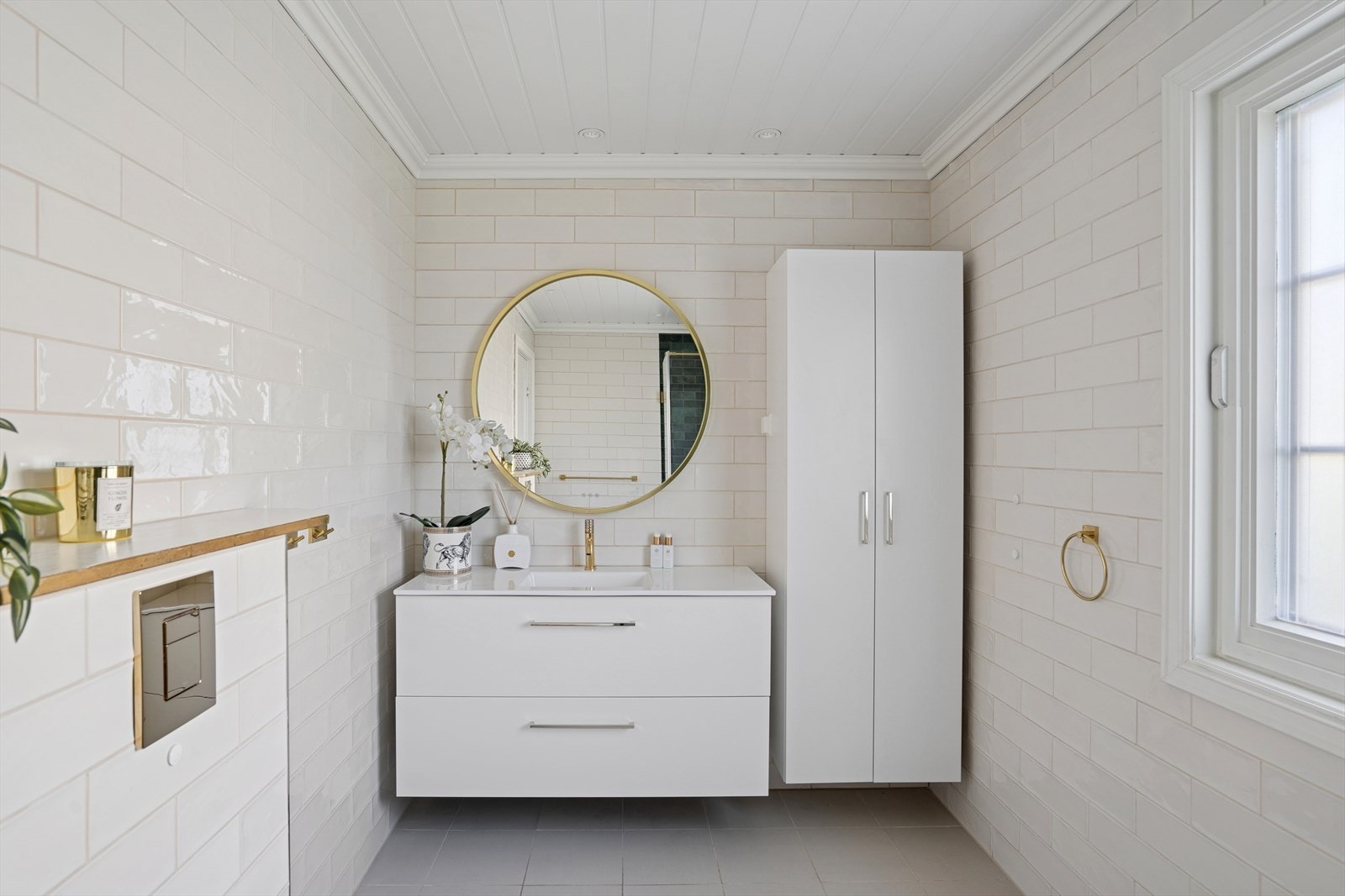 Innredningen består av servant med nedfelt vask, speil på vegg, benkeskap og veggskap med glatte fronter. Galleribilde