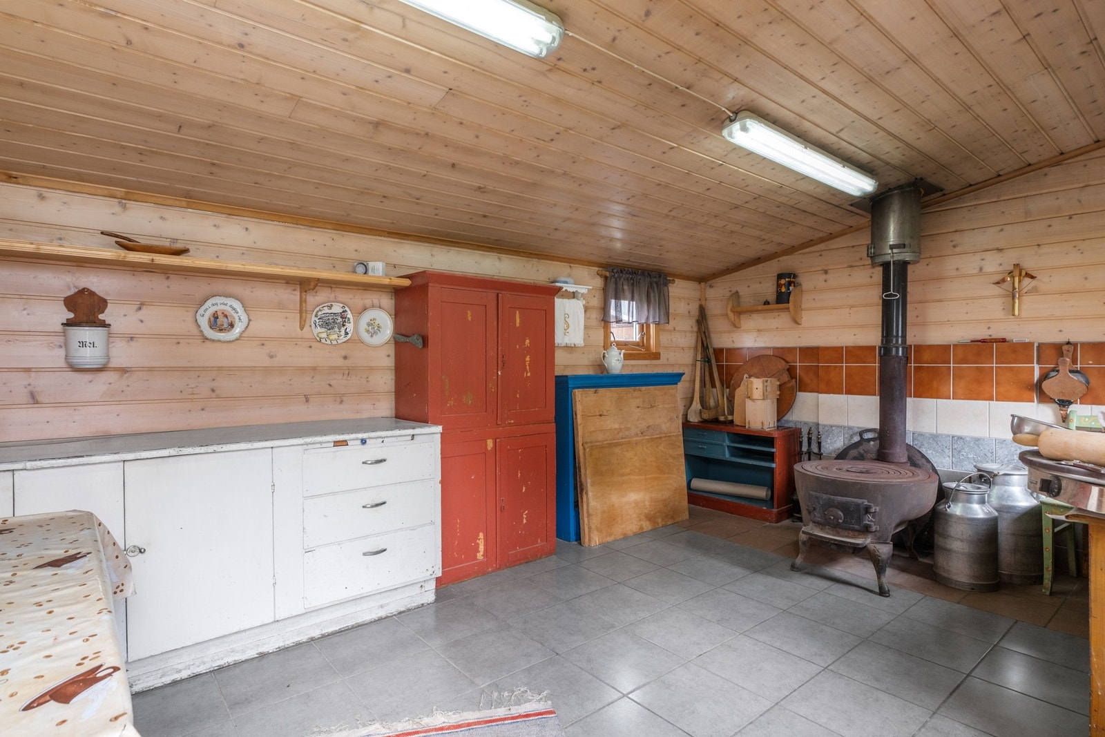 Baktshus er innredet med flislagt gulv og panel på vegger og tak. Lukket ildsted med stålpipe. Galleribilde