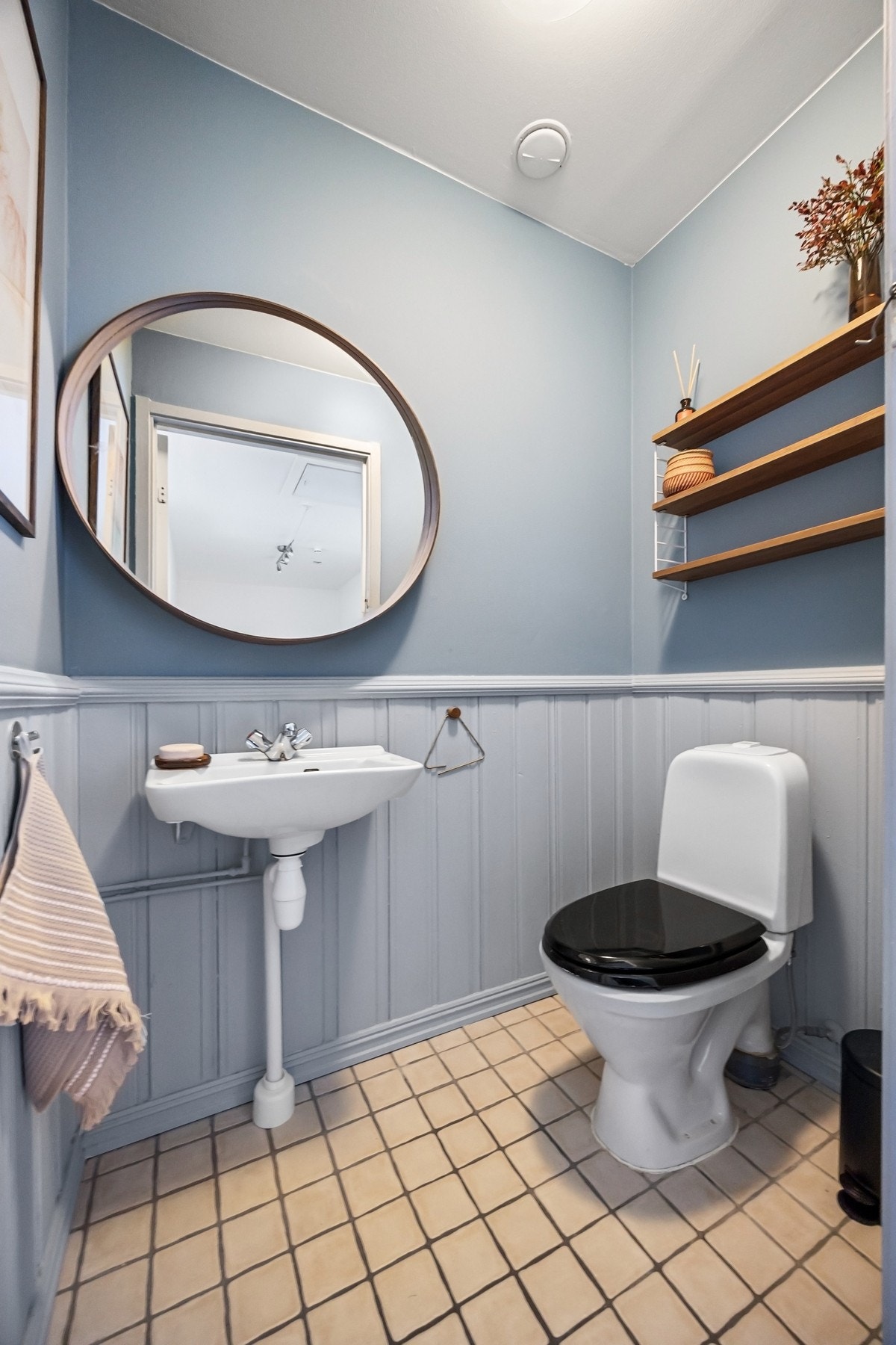 Toalettrom med gulvmontert toalett og enkel servant Galleribilde